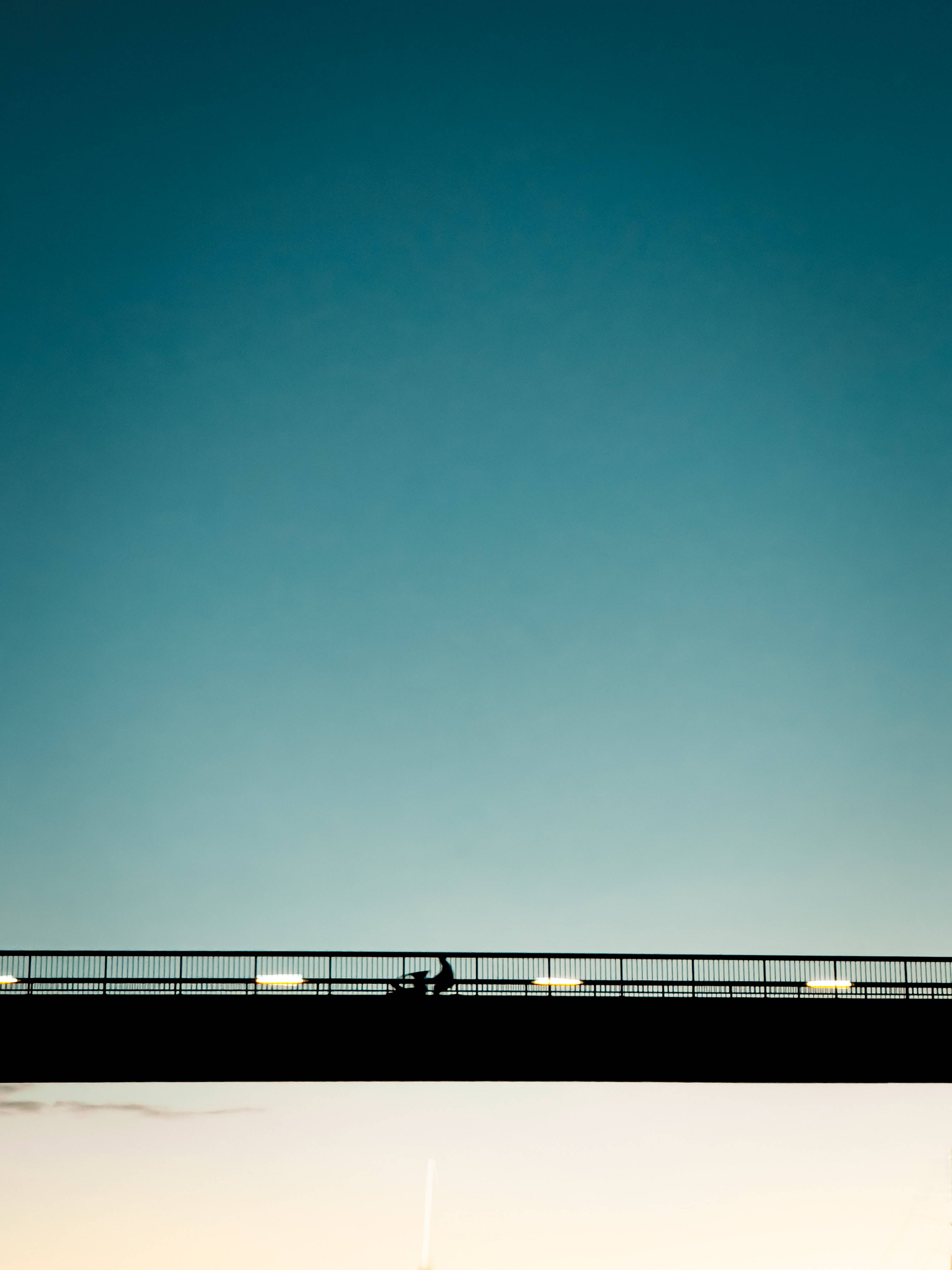 green minimalist landscape, lone cyclist, vast gradient sky, 4K Phone Wallpaper