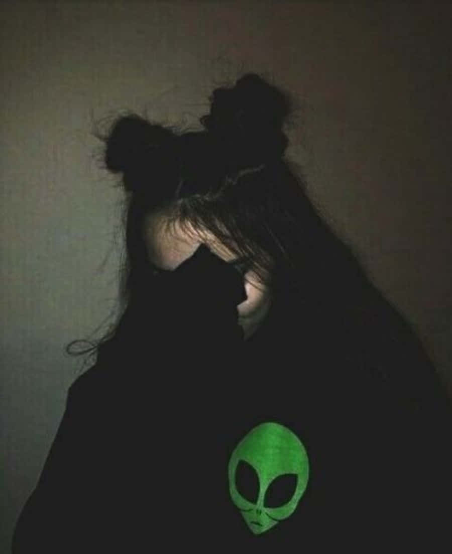 black hoodie, glowing green alien head, dim wall, SD Phone Wallpaper