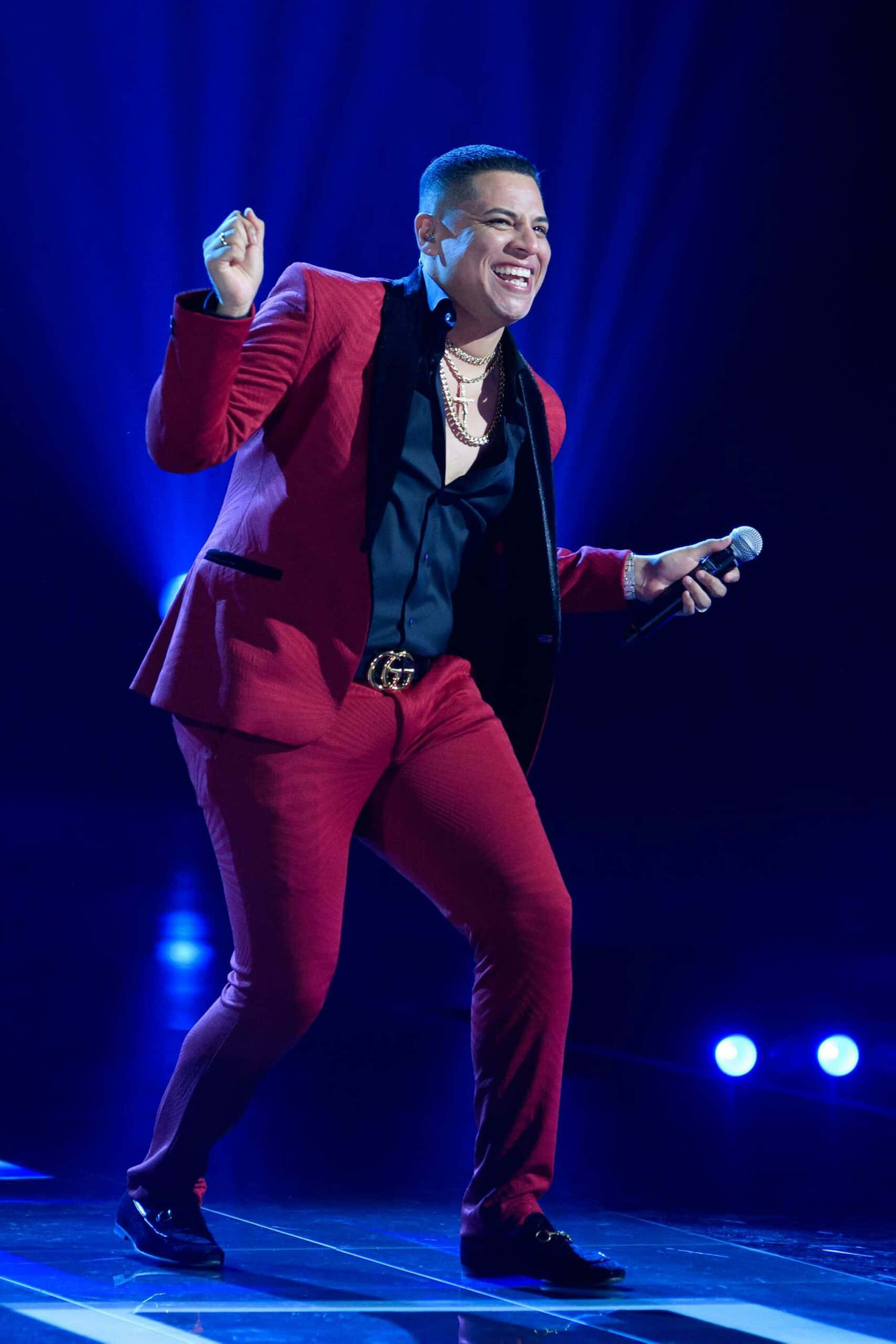 Grupo Firme, red suit, blue-lit stage, 2K Phone Wallpaper