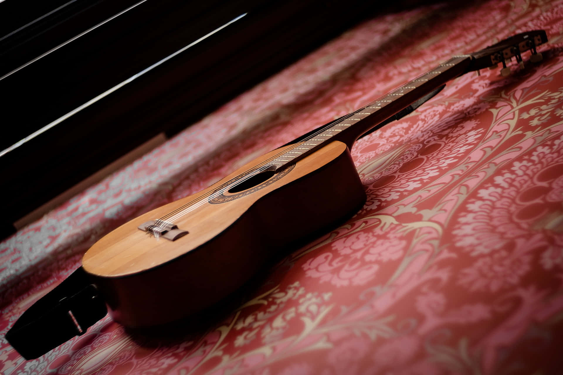 wooden acoustic guitar, red damask patterned fabric, warm directional lighting, Full HD Desktop Wallpaper