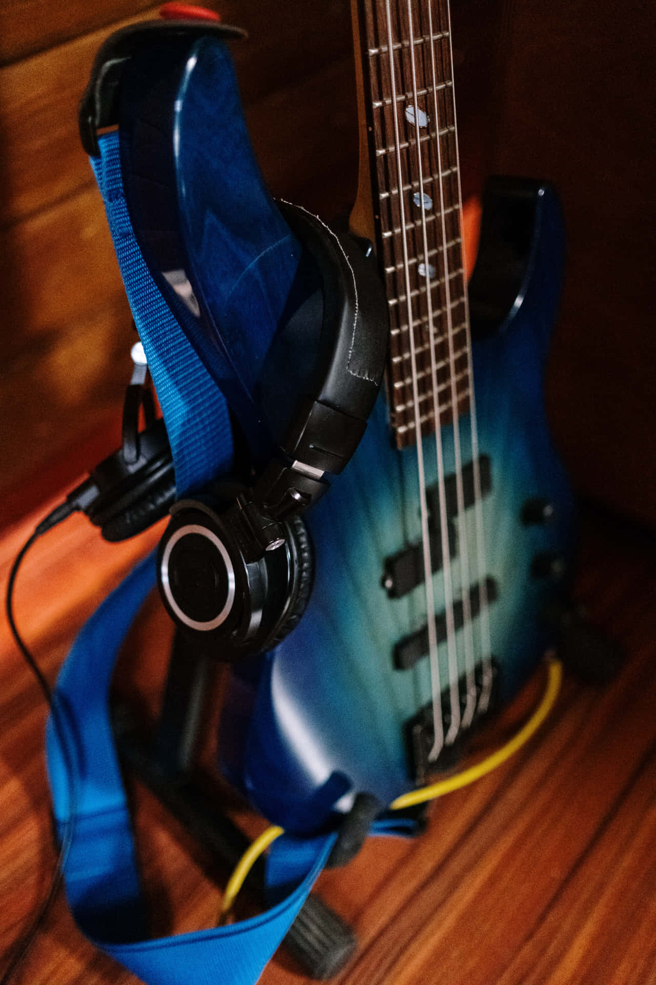 blue gradient bass guitar, black headphones, wooden floor, Full HD Phone Wallpaper