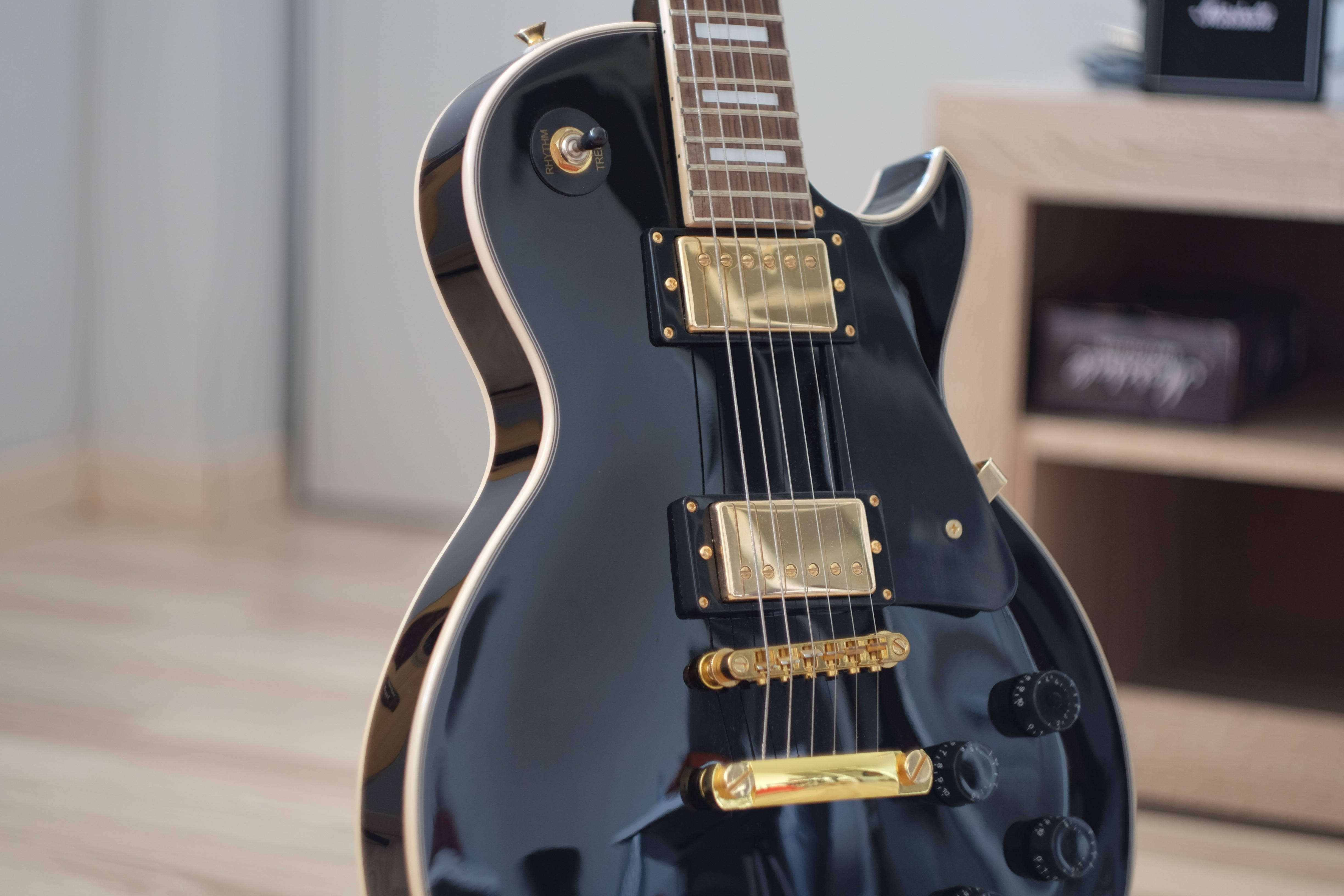 glossy black electric guitar, gold hardware, wooden flooring, 4K Desktop Wallpaper
