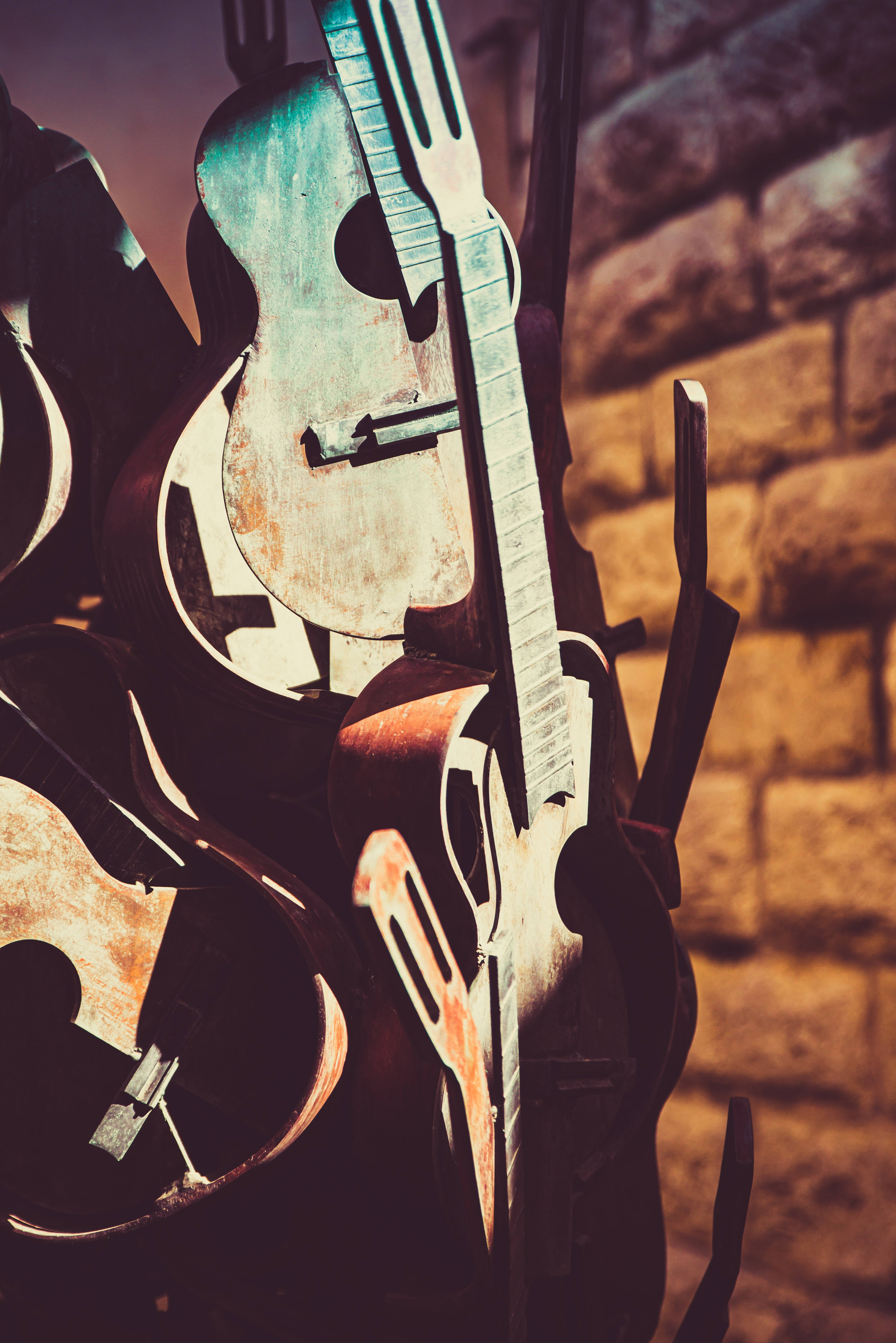 vintage guitars, warm-toned brick wall, moody lighting, 5K Phone Wallpaper