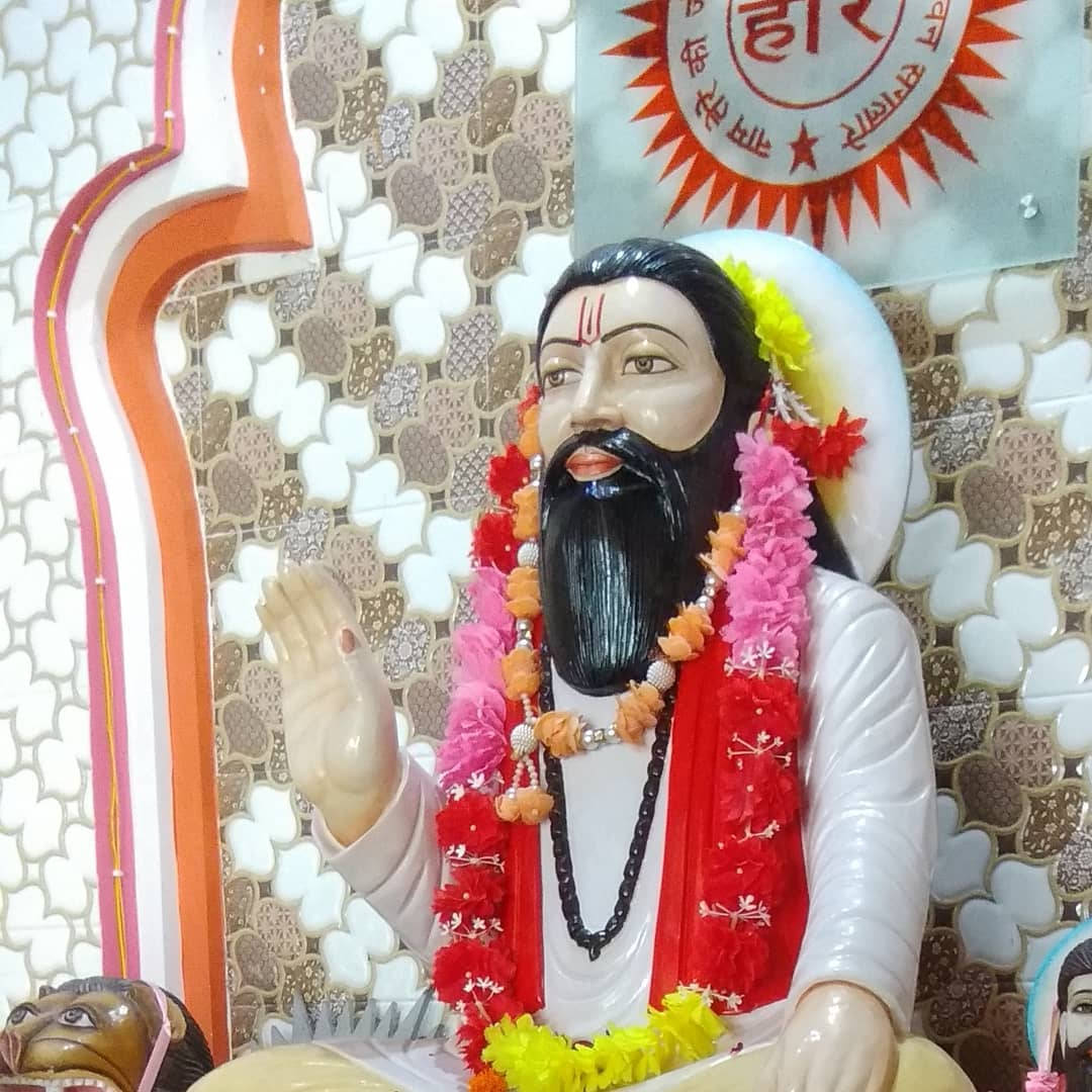 Guru Ravidass, bearded deity, vibrant pink yellow and red flower garlands, SD Desktop Wallpaper