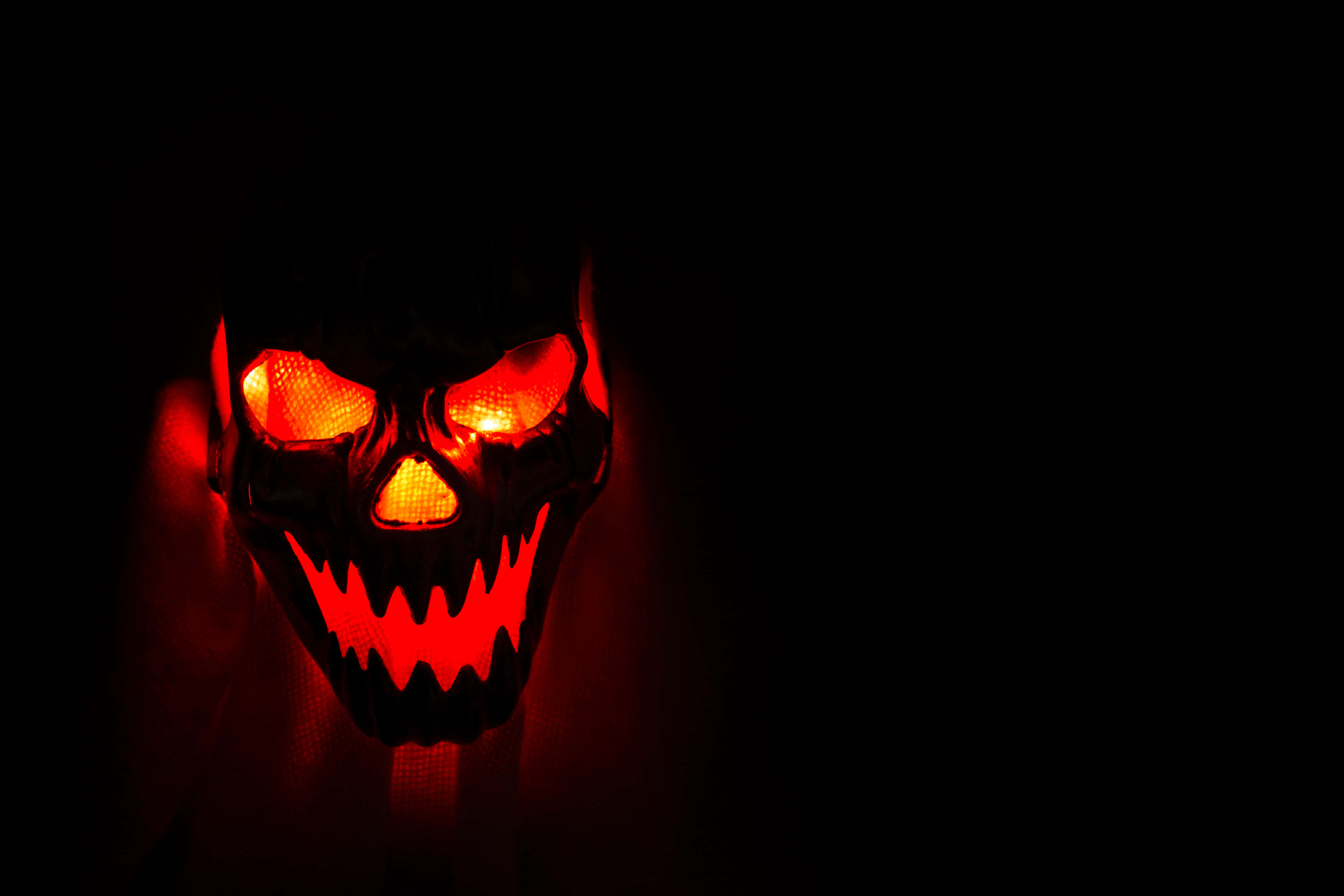 glowing red skull mask, fierce eyes, jagged teeth, 5K Desktop Wallpaper