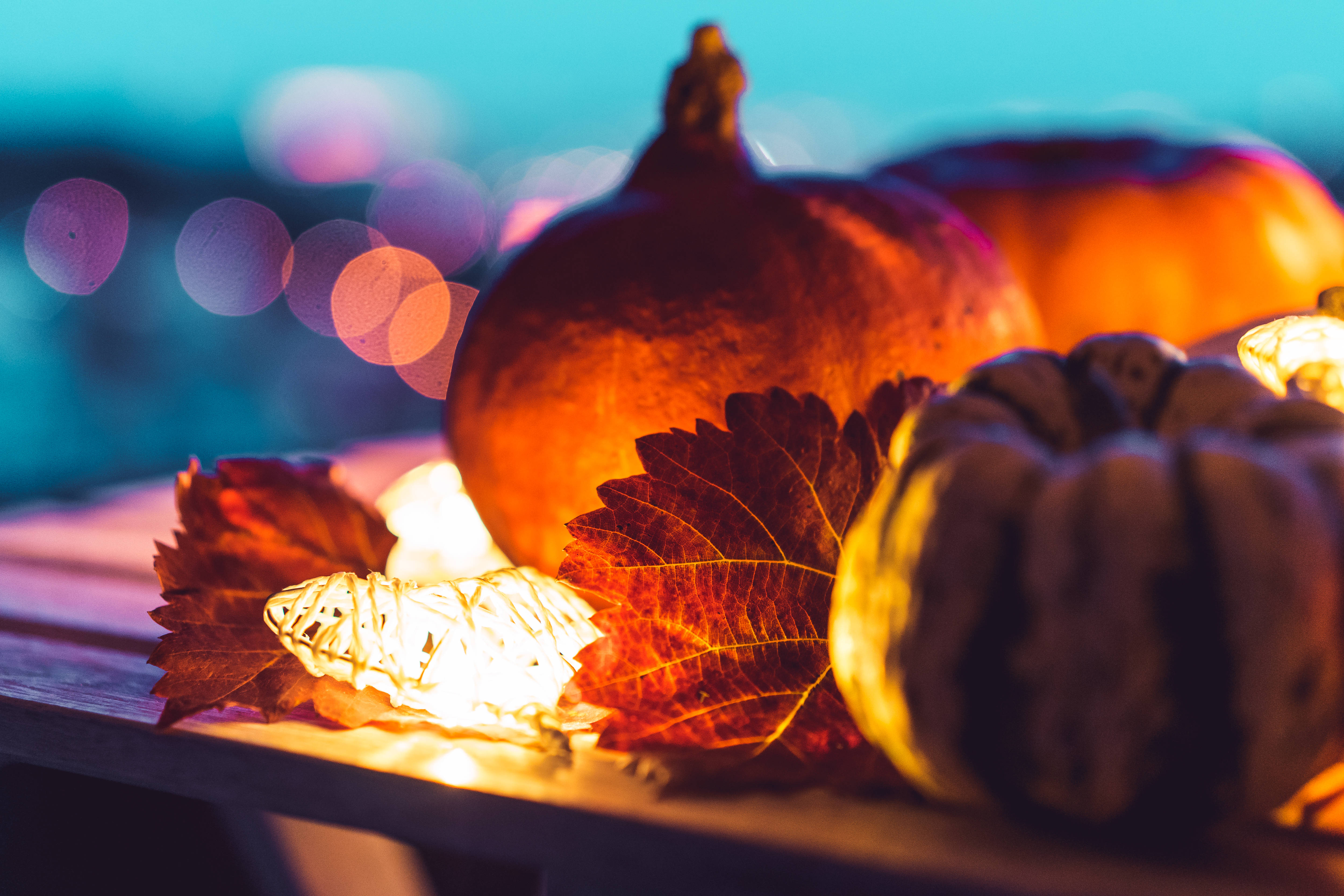 pumpkin with lights, autumn leaves, wooden surface, 4K Desktop Wallpaper