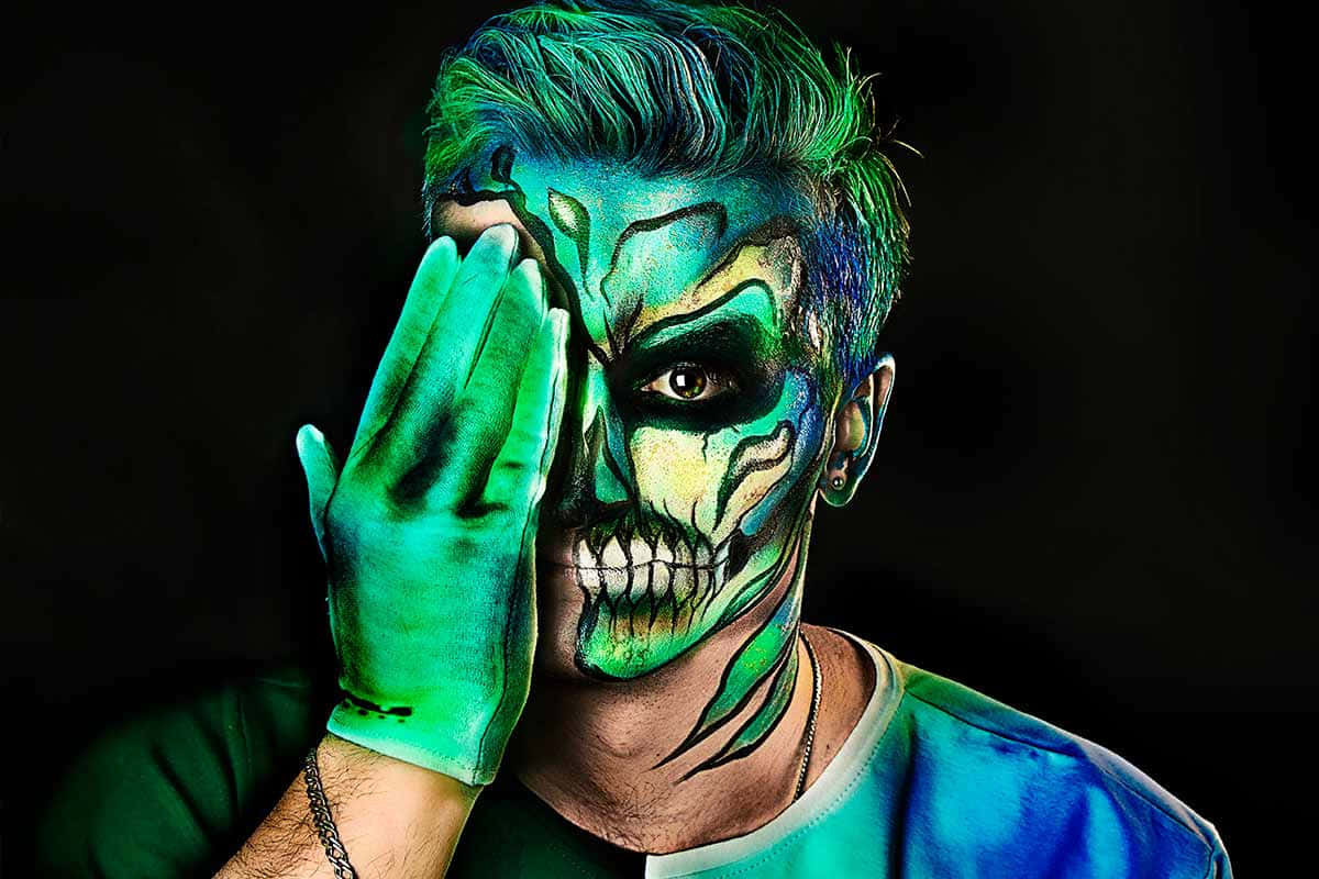glowing green skull face paint, gloved hand, black background, SD Desktop Wallpaper