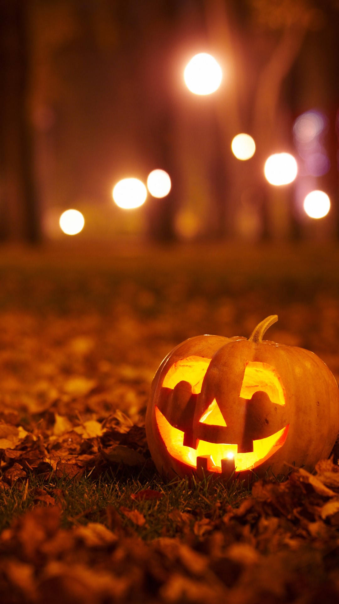 glowing jack-o'-lantern, autumn leaves, warm streetlights, Full HD Phone Wallpaper