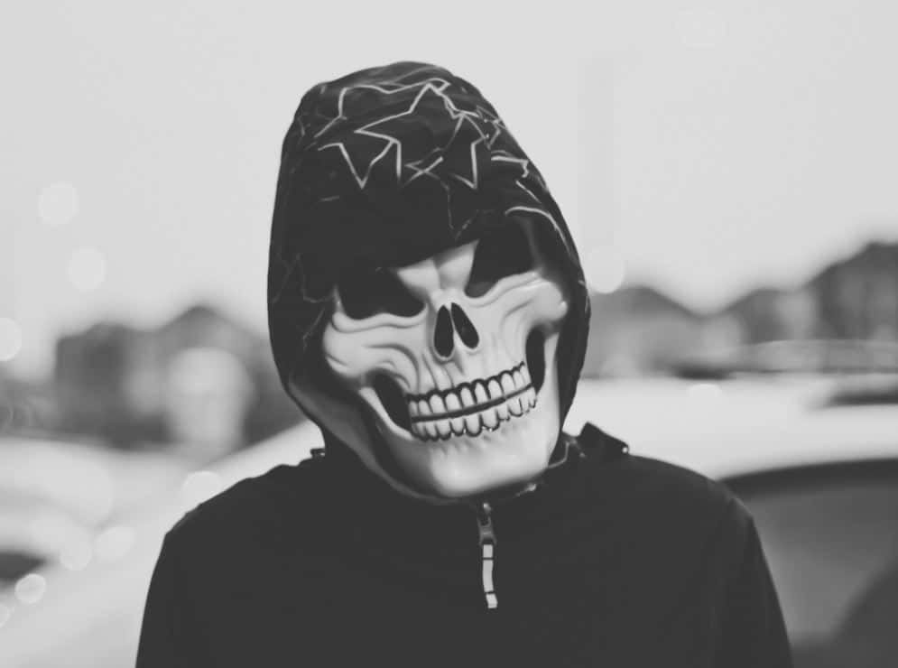 skull mask, hooded jacket, blurred urban setting, SD Desktop Wallpaper