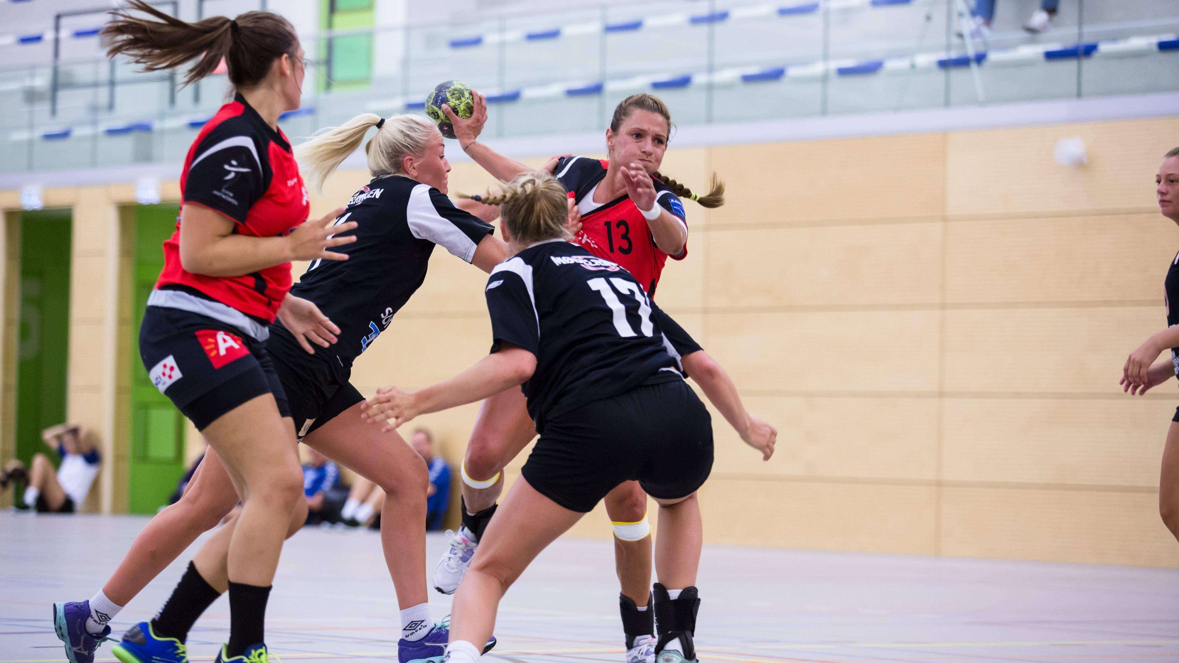 Handball Women's Game, red and black jerseys, brightly lit indoor court, 4K Desktop Wallpaper