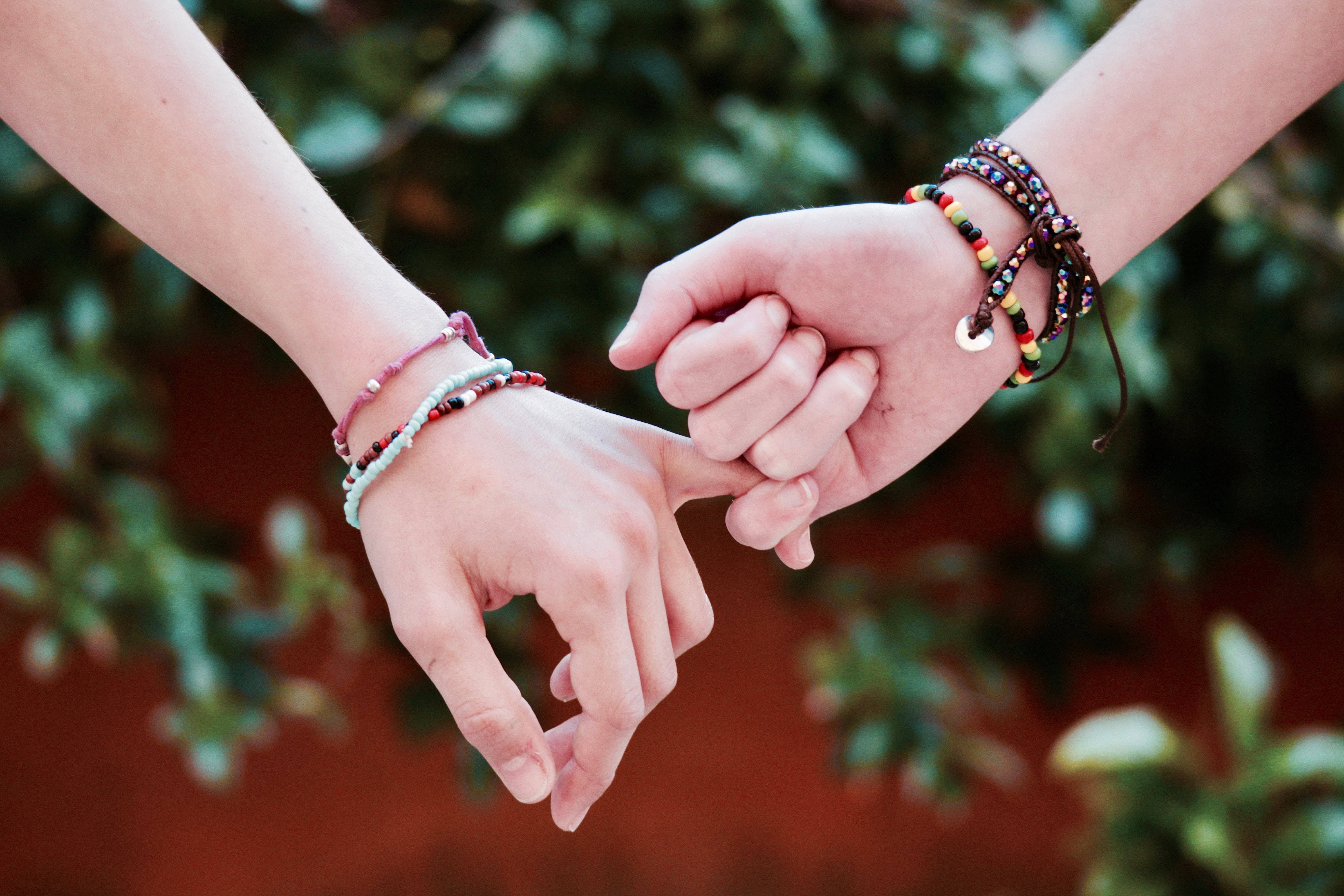 hands, colorful beaded bracelets, green background, 5K Desktop Wallpaper