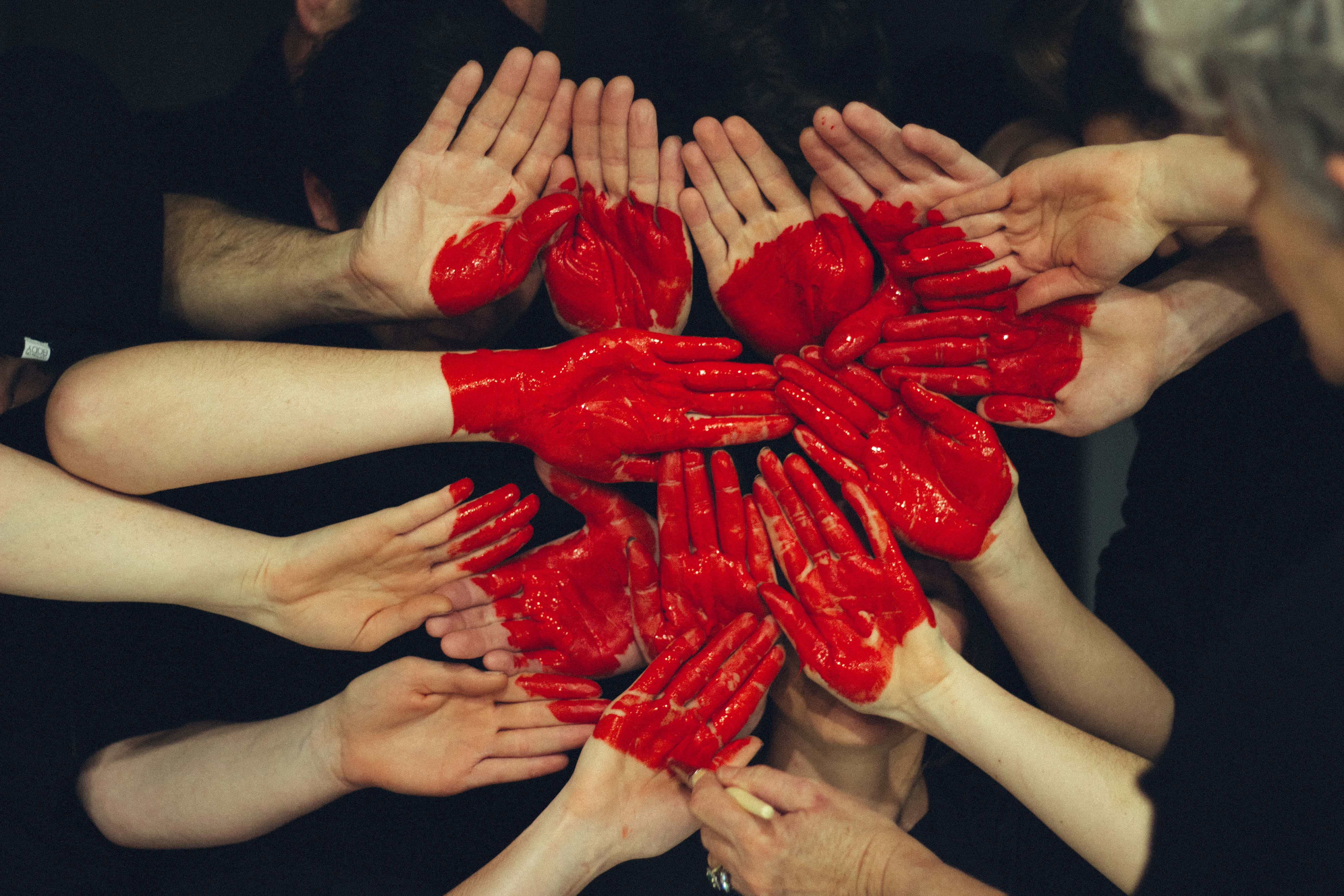 Unityin Caring Heart Hands, vibrant red paint, circular formation, 5K Desktop Wallpaper