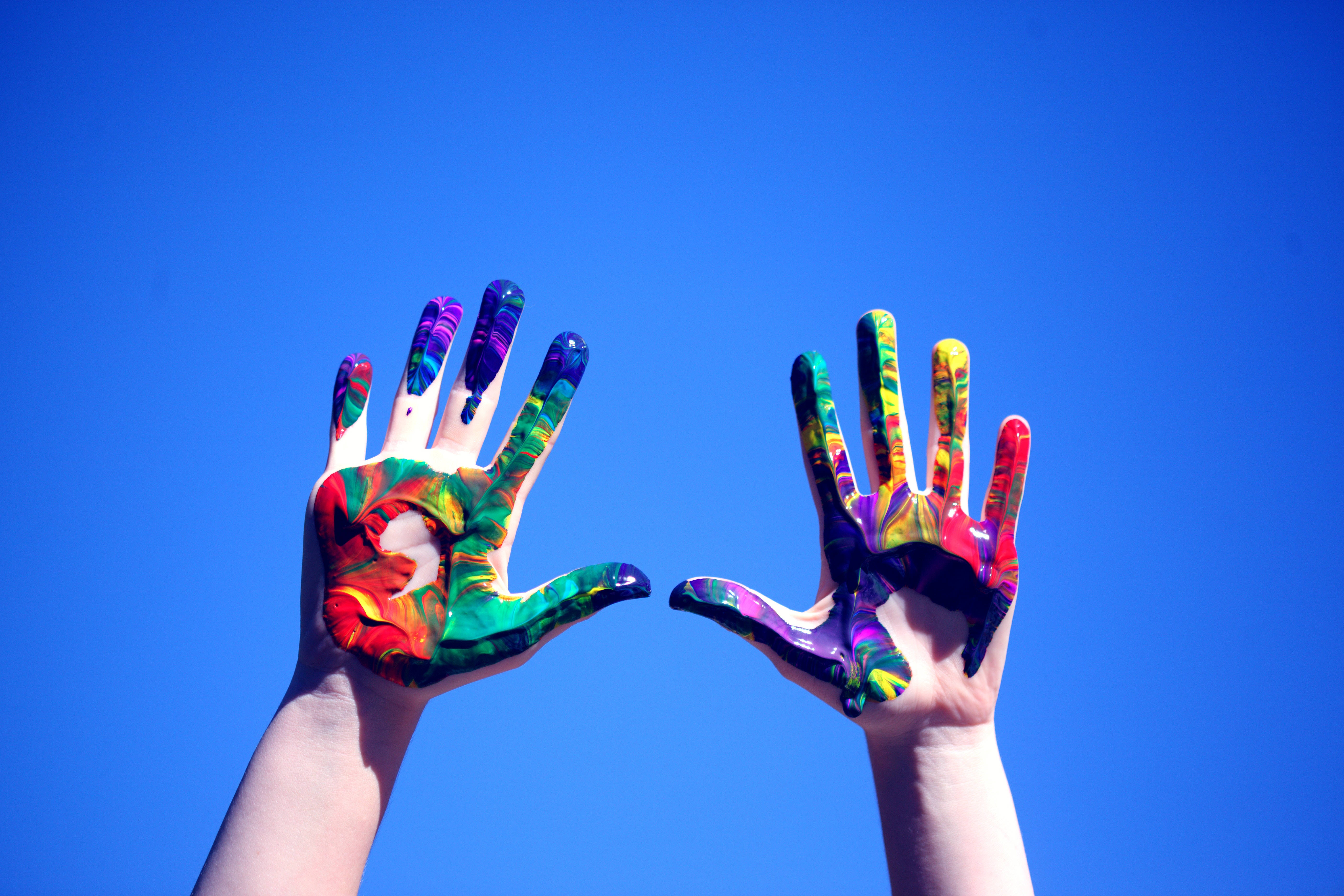 vibrant swirling paint, clear blue sky, two hands, 5K Desktop Wallpaper