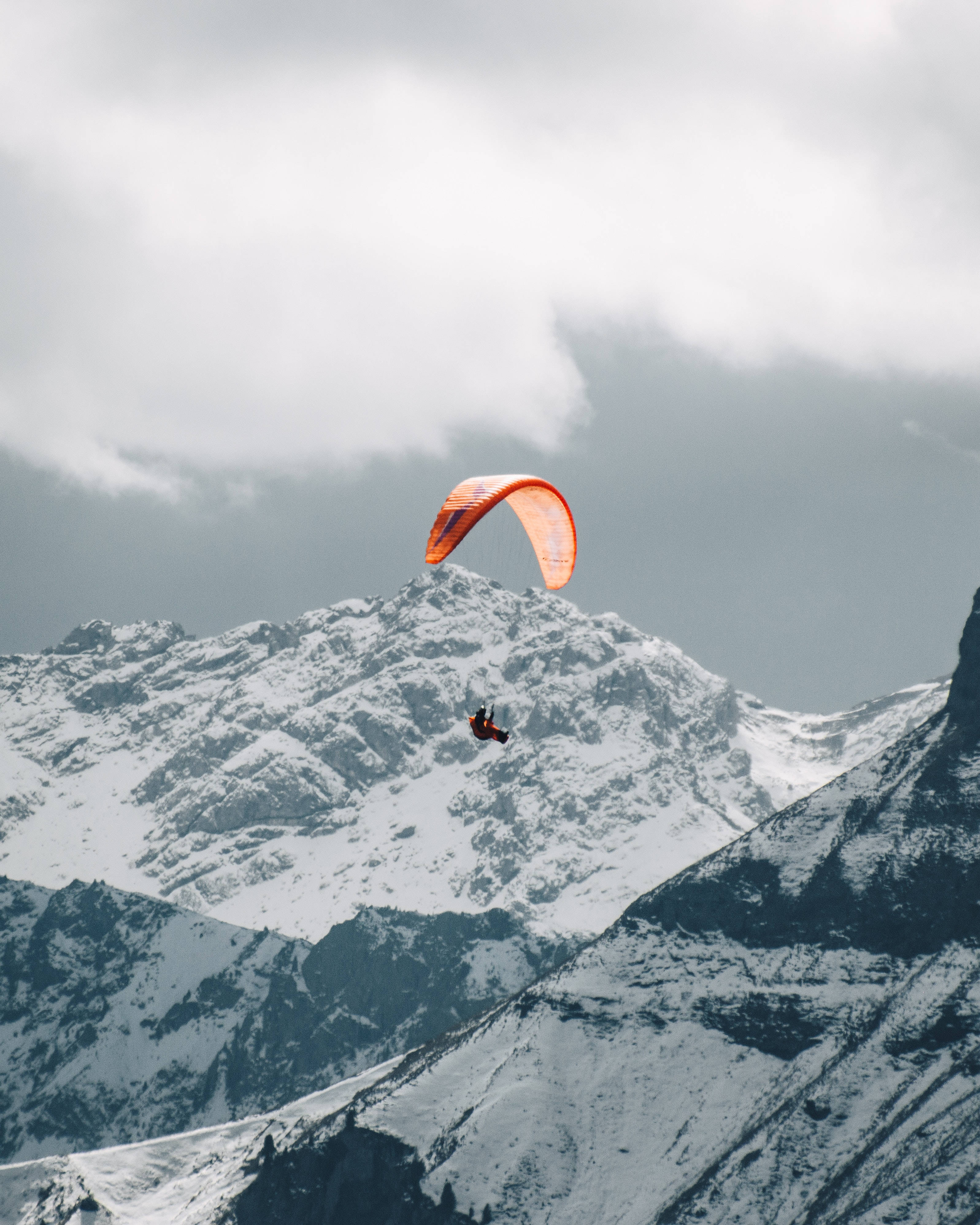 brave paraglider, bright orange, snowcapped mountains, 4K Phone Wallpaper