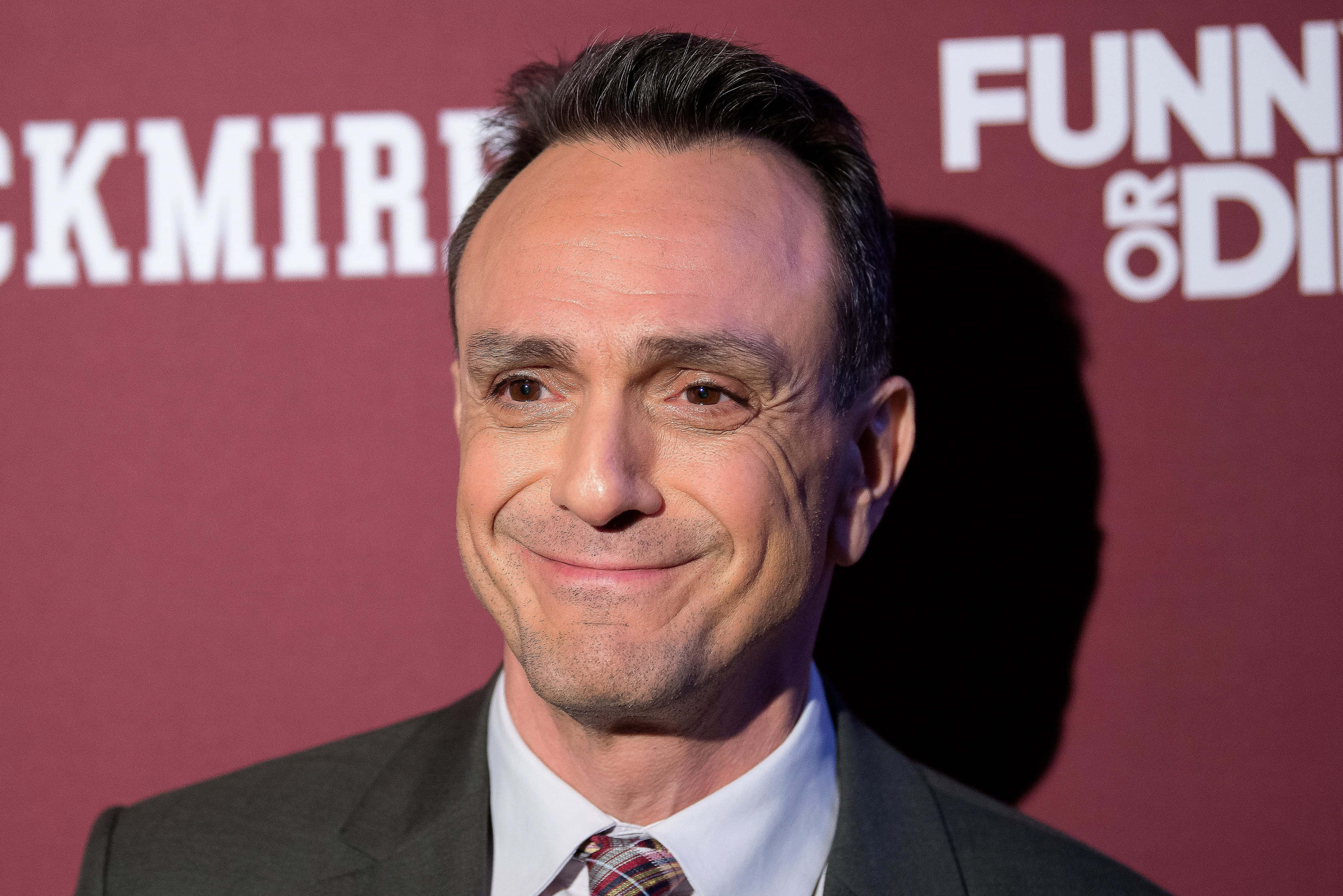 Hank Azaria, maroon backdrop, white text, 4K Desktop Wallpaper