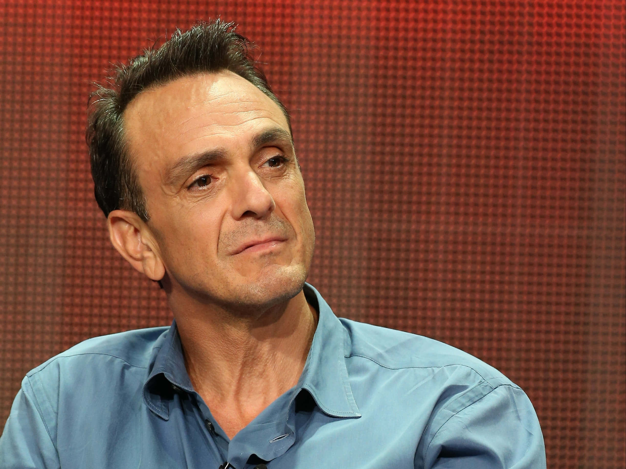 Hank Azaria, blue shirt, red pixelated backdrop, 2K Desktop Wallpaper