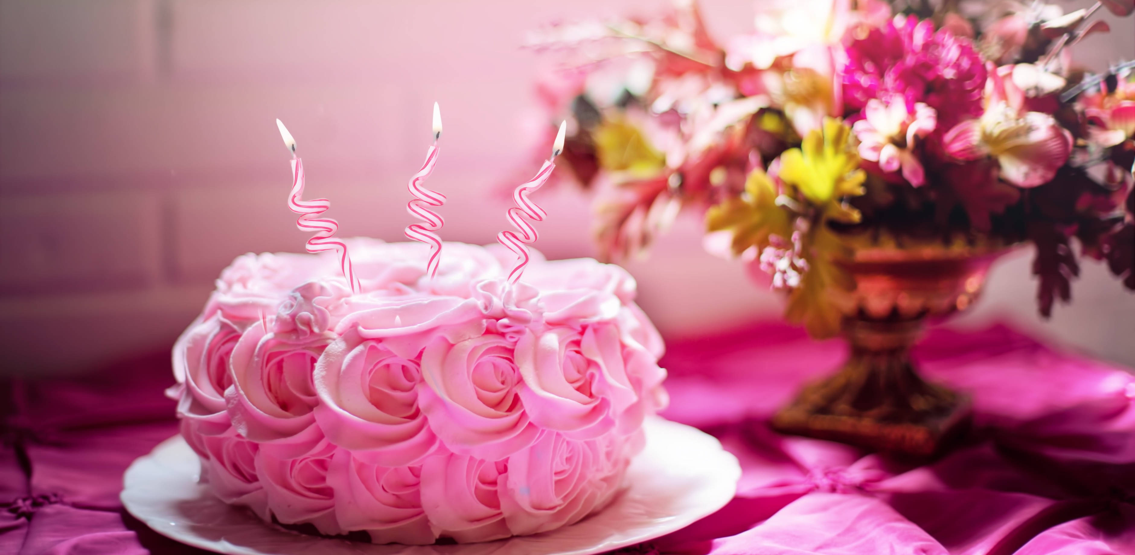 pink rose-shaped cake, three lit candles, magenta tablecloth, 2K Desktop Wallpaper