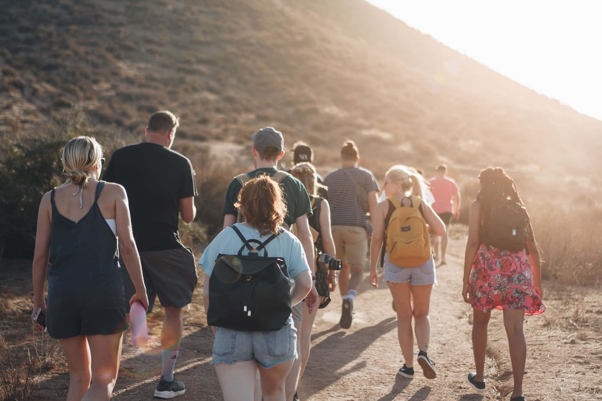 joyful youth group celebration, sunlit dirt trail, dry grassy hillside, Full HD Desktop Wallpaper