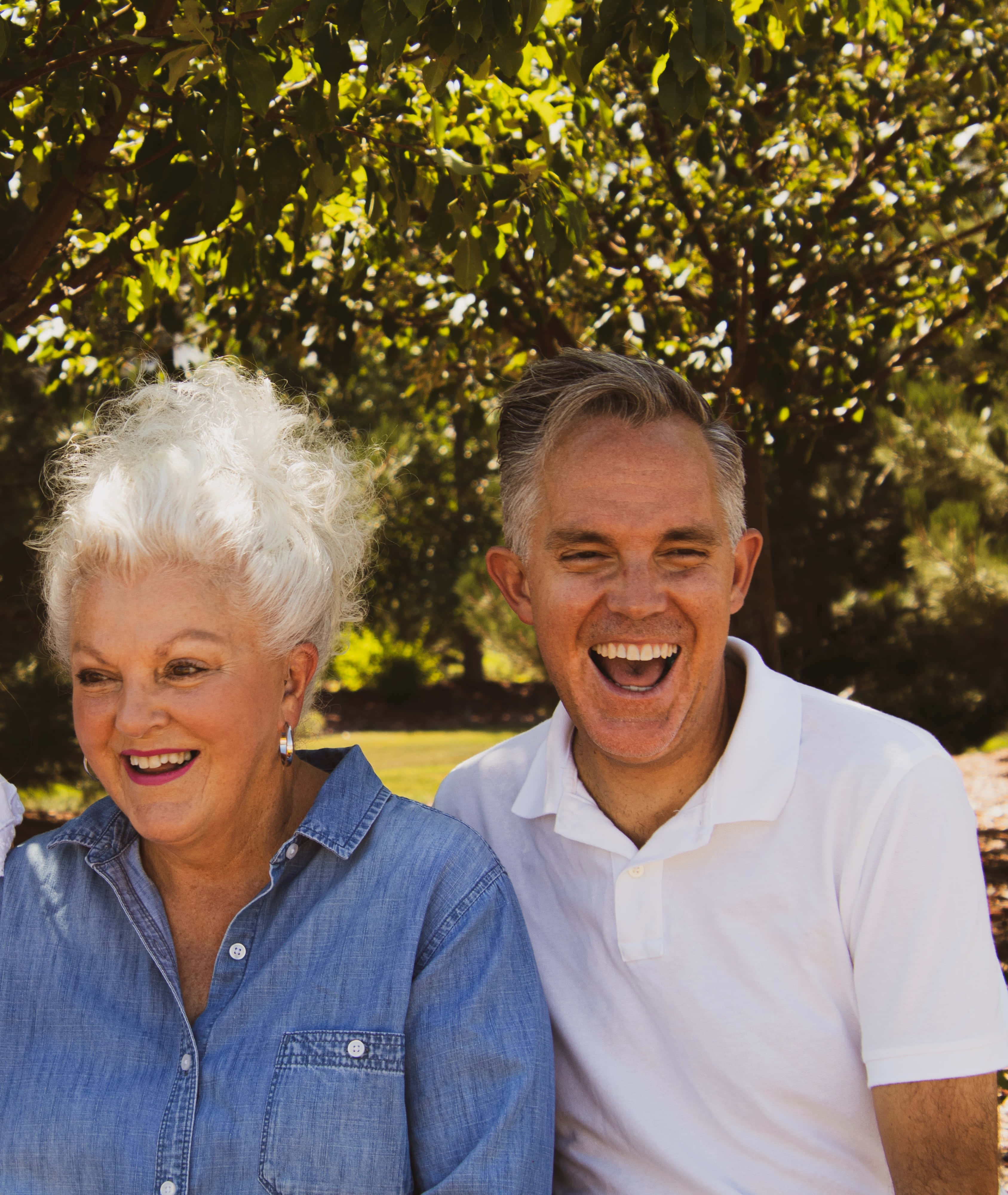 Mature Happy Couple, dappled sunlight, lush green trees, 4K Phone Wallpaper