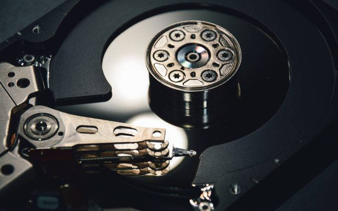 black and gold computer hard drive, spinning platter, read/write head, SD Desktop Wallpaper