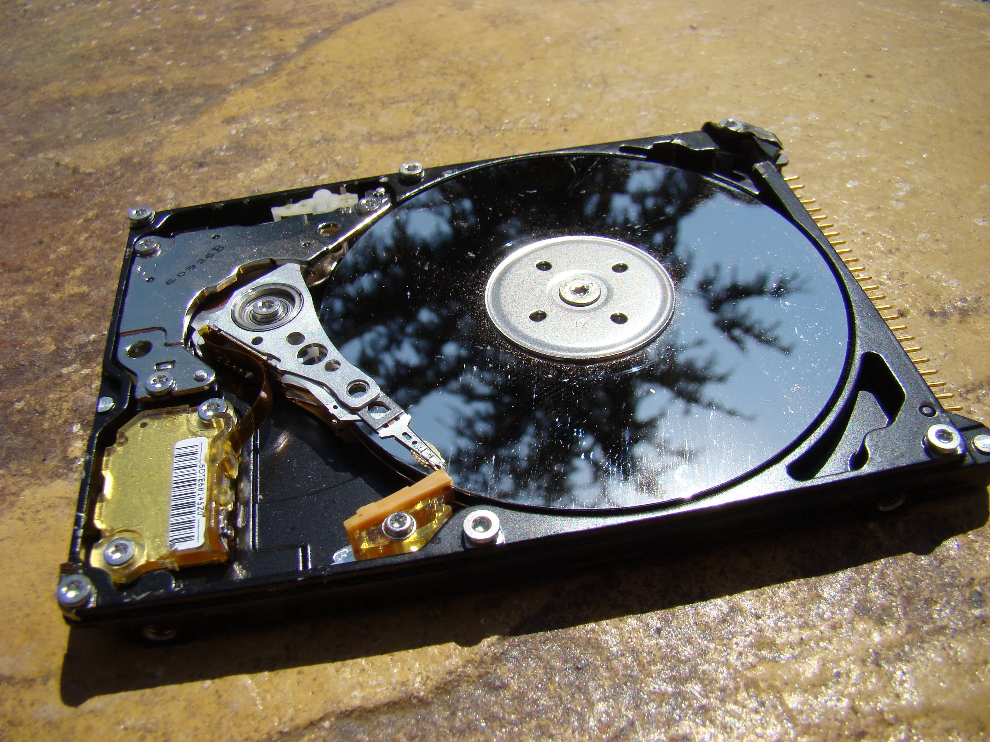 computer hard drive, black platter, concrete surface, 2K Desktop Wallpaper