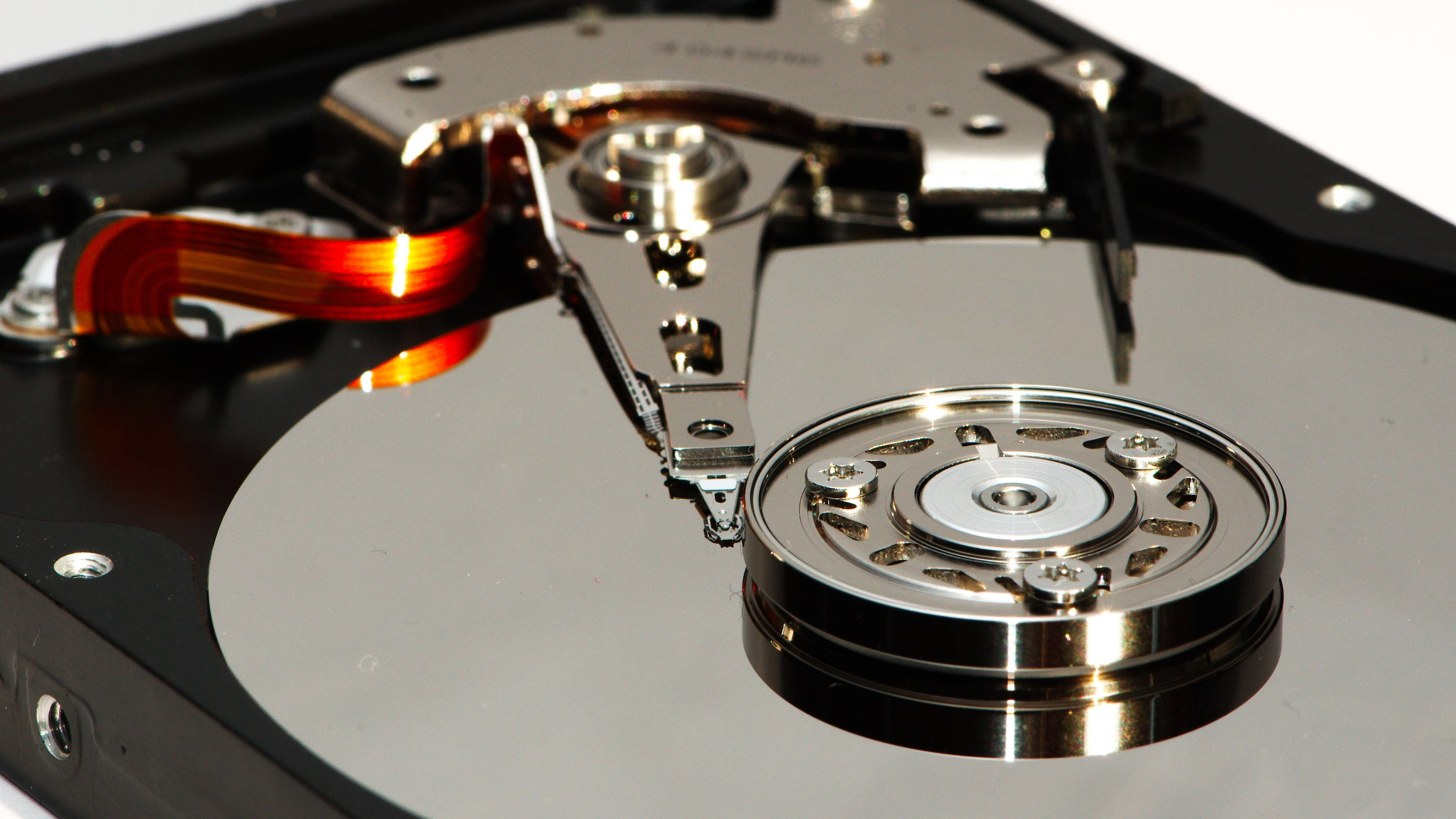 magnetic computer hard drive, shiny metallic platters, red ribbon cable, 4K Desktop Wallpaper