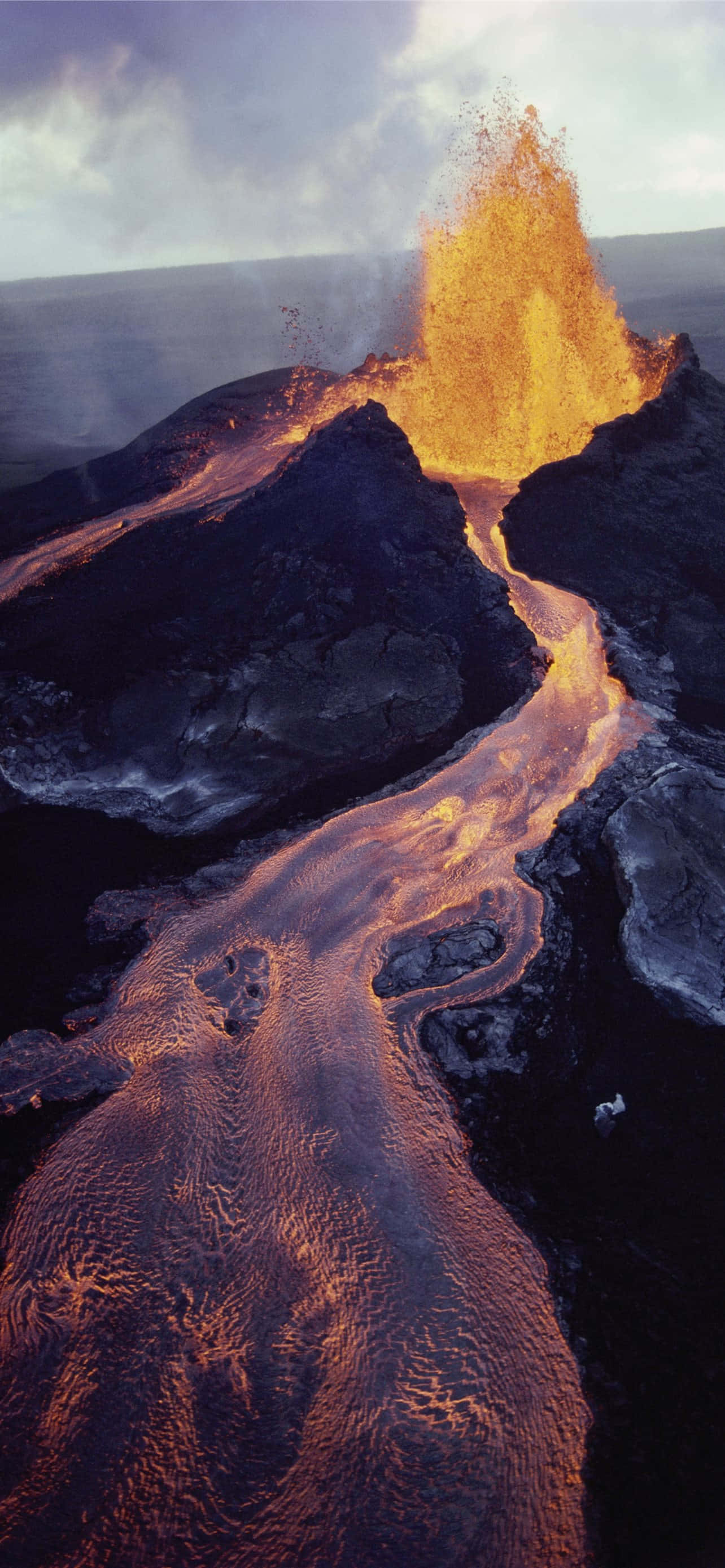 Hawaii Volcanoes National Park, glowing orange lava, rugged black rock, 2K Phone Wallpaper