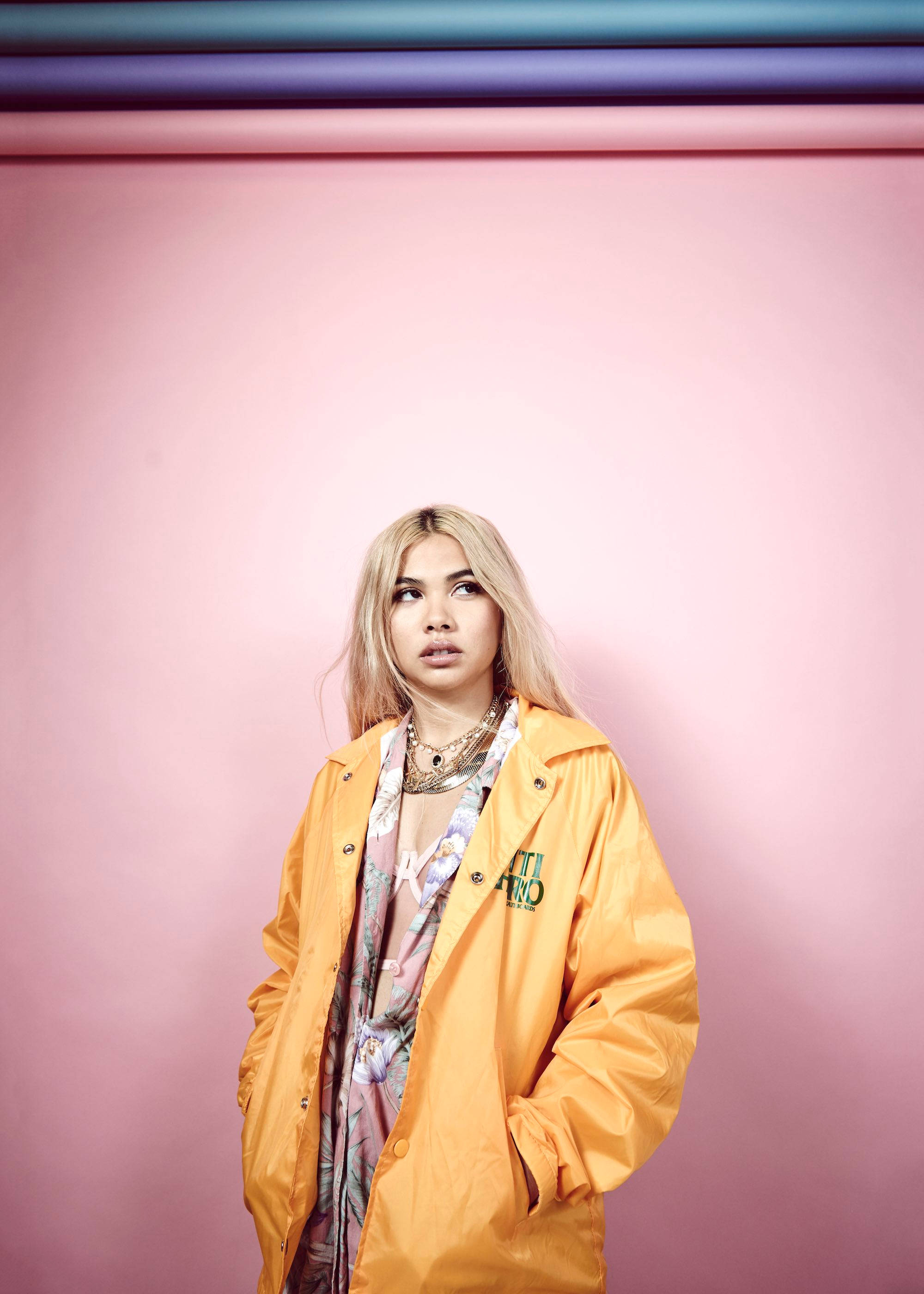 Hayley Kiyoko, yellow raincoat, soft pink wall, 2K Phone Wallpaper