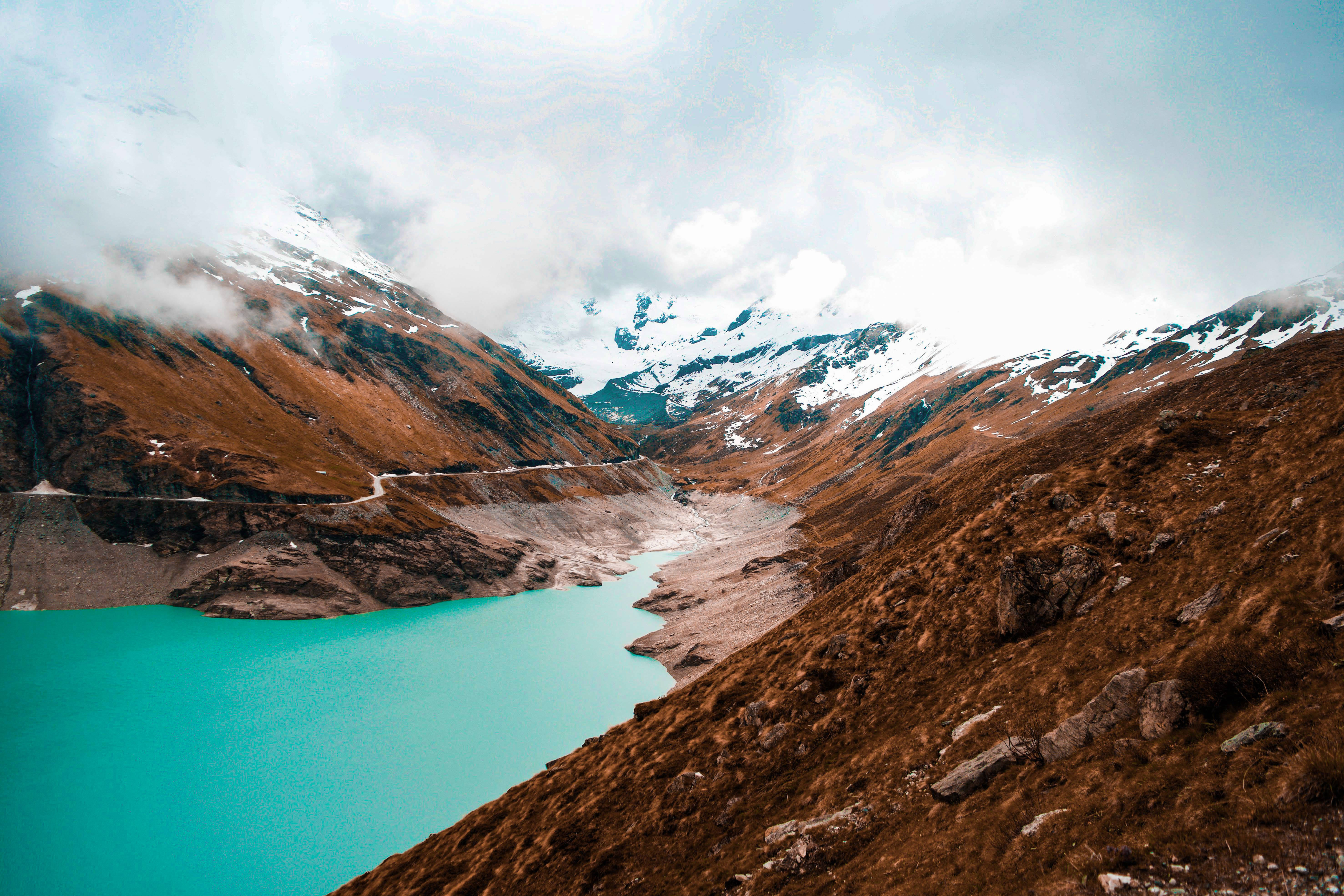 turquoise lake, rugged brown mountains, snow-capped peaks, 5K Desktop Wallpaper