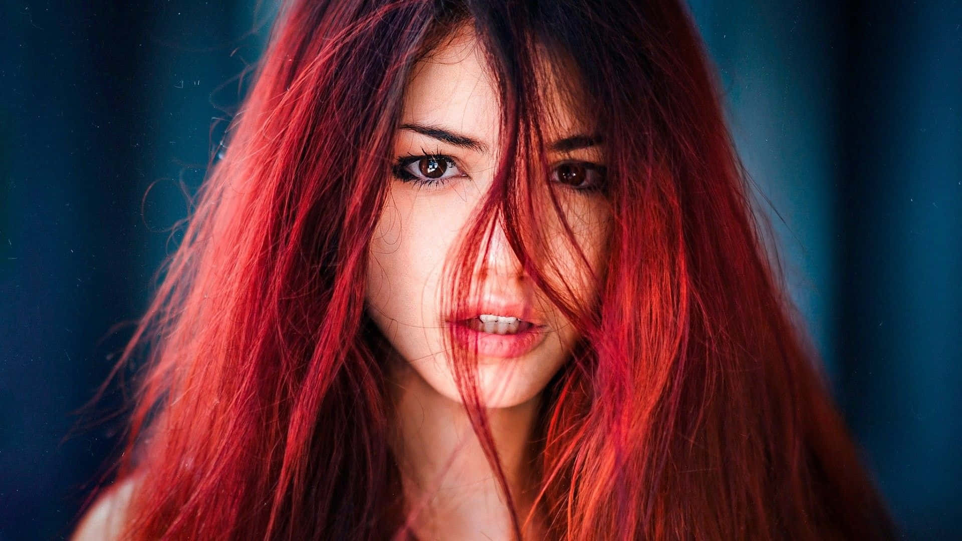 fiery red hair, intense gaze, deep blue blurred background, Full HD Desktop Wallpaper