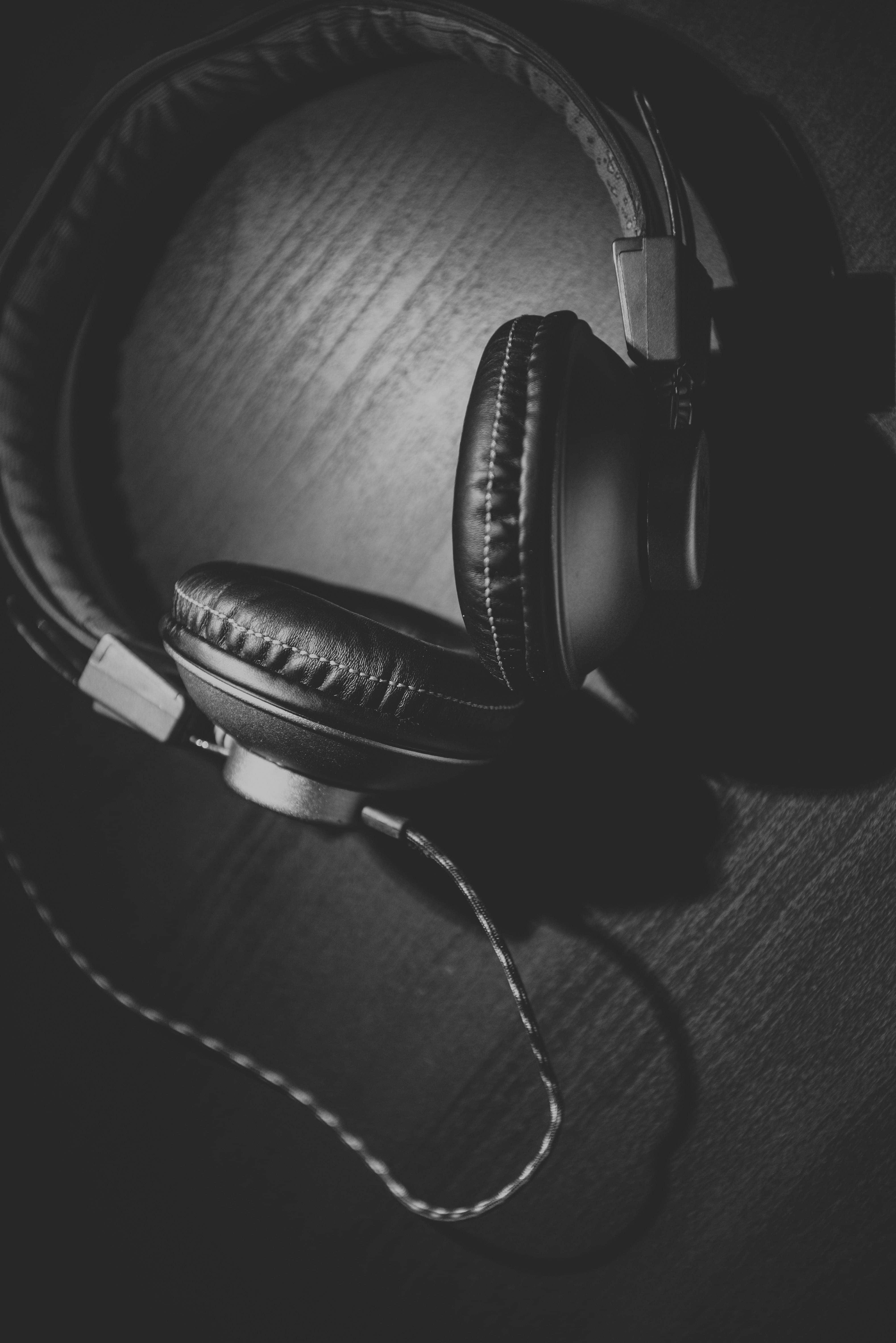 black and white headphones, over-ear headphones, dark wooden surface, 5K Phone Wallpaper