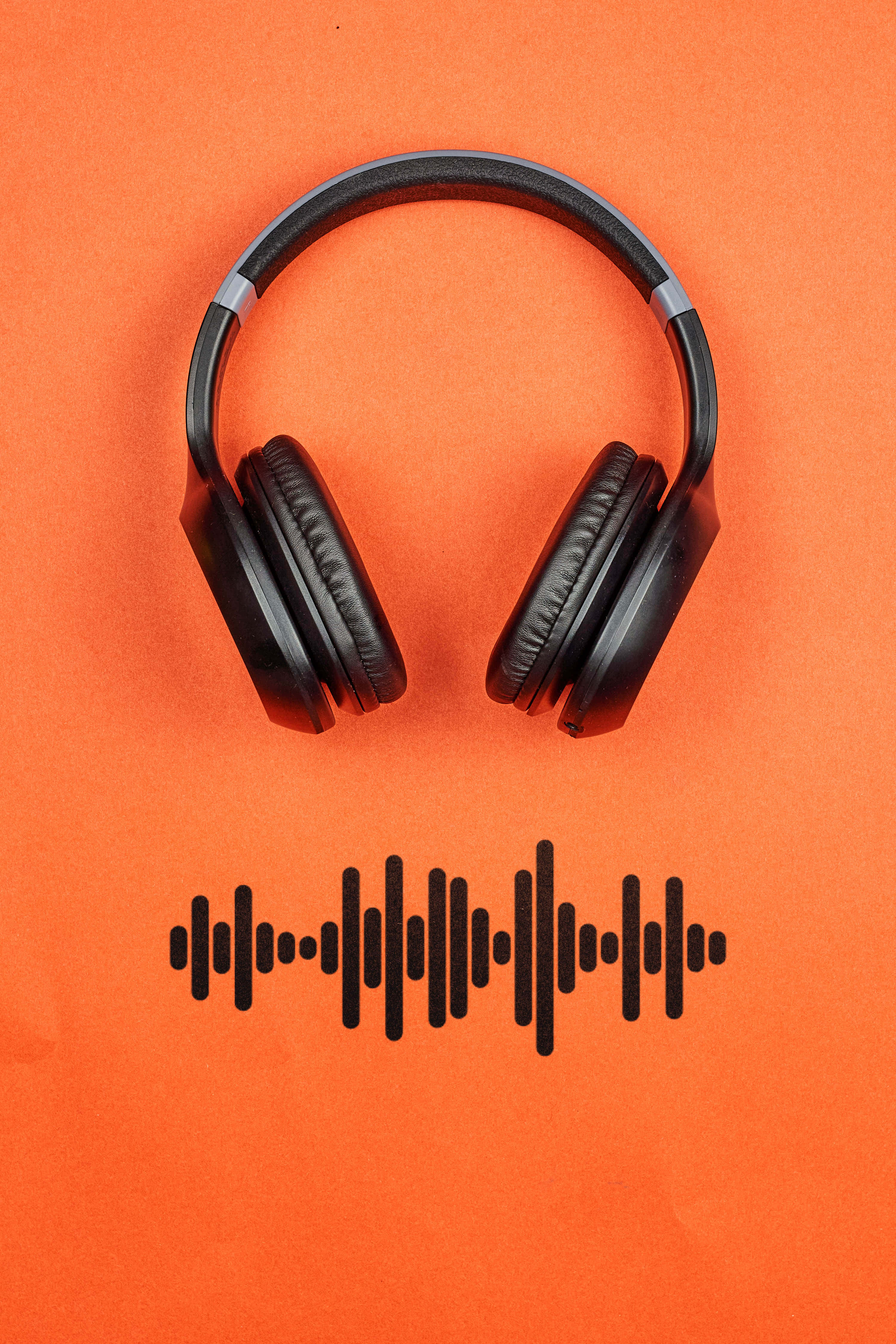 black headphones, orange background, soundwave graphic, 4K Phone Wallpaper