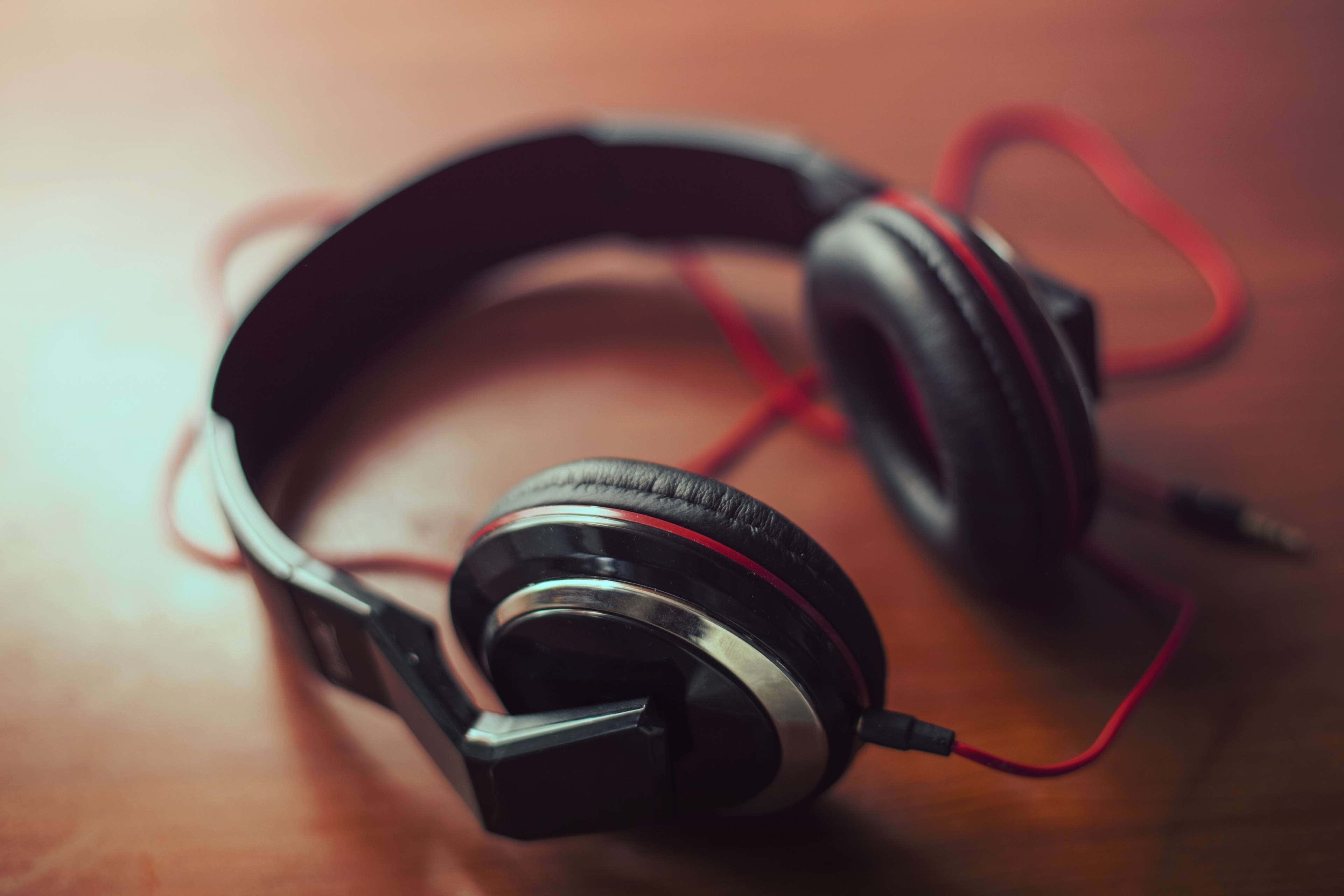 black headphones, red cable, warm wooden surface, 4K Desktop Wallpaper