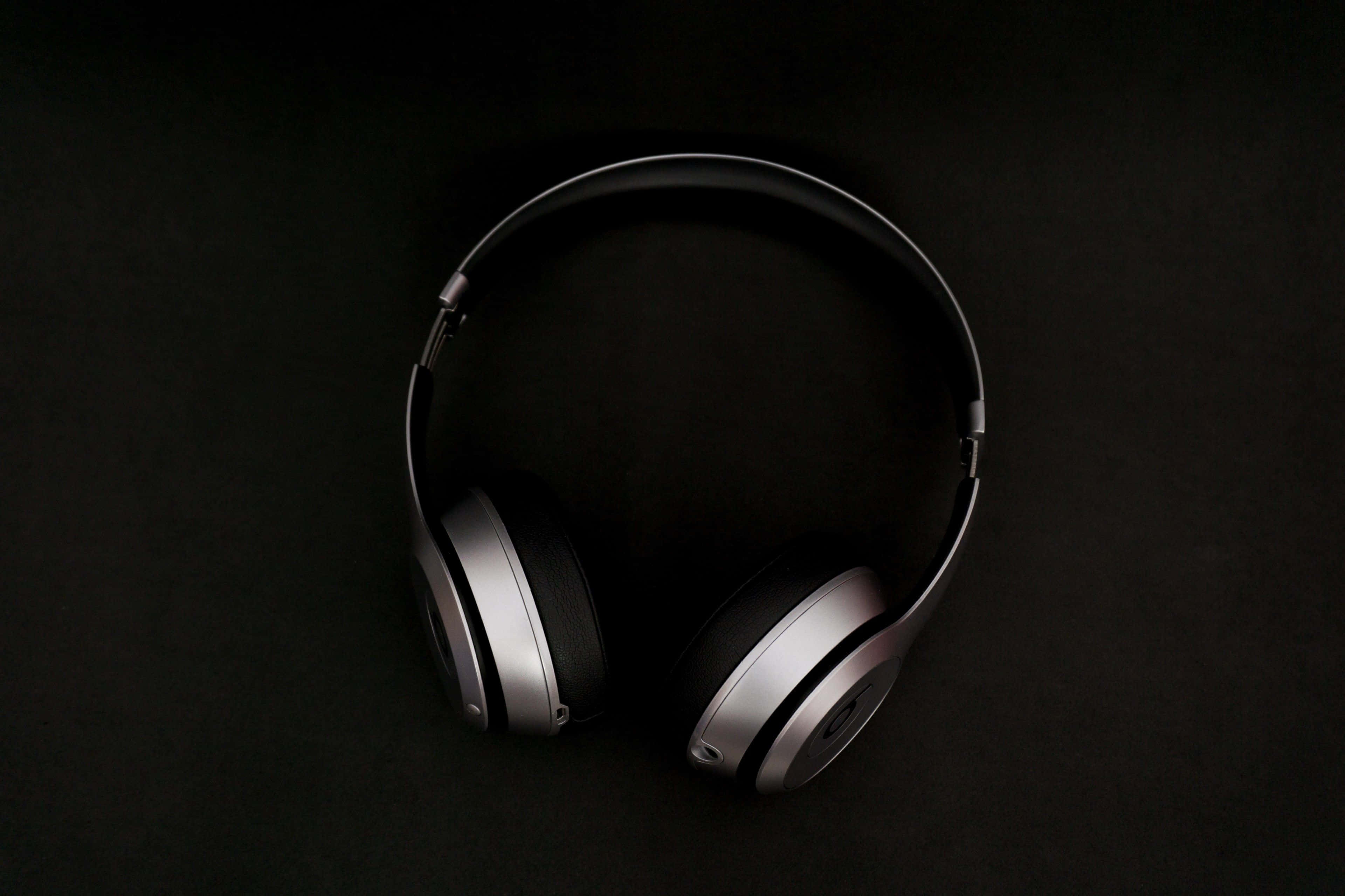 black headphones, silver accents, dark textured surface, 4K Desktop Wallpaper