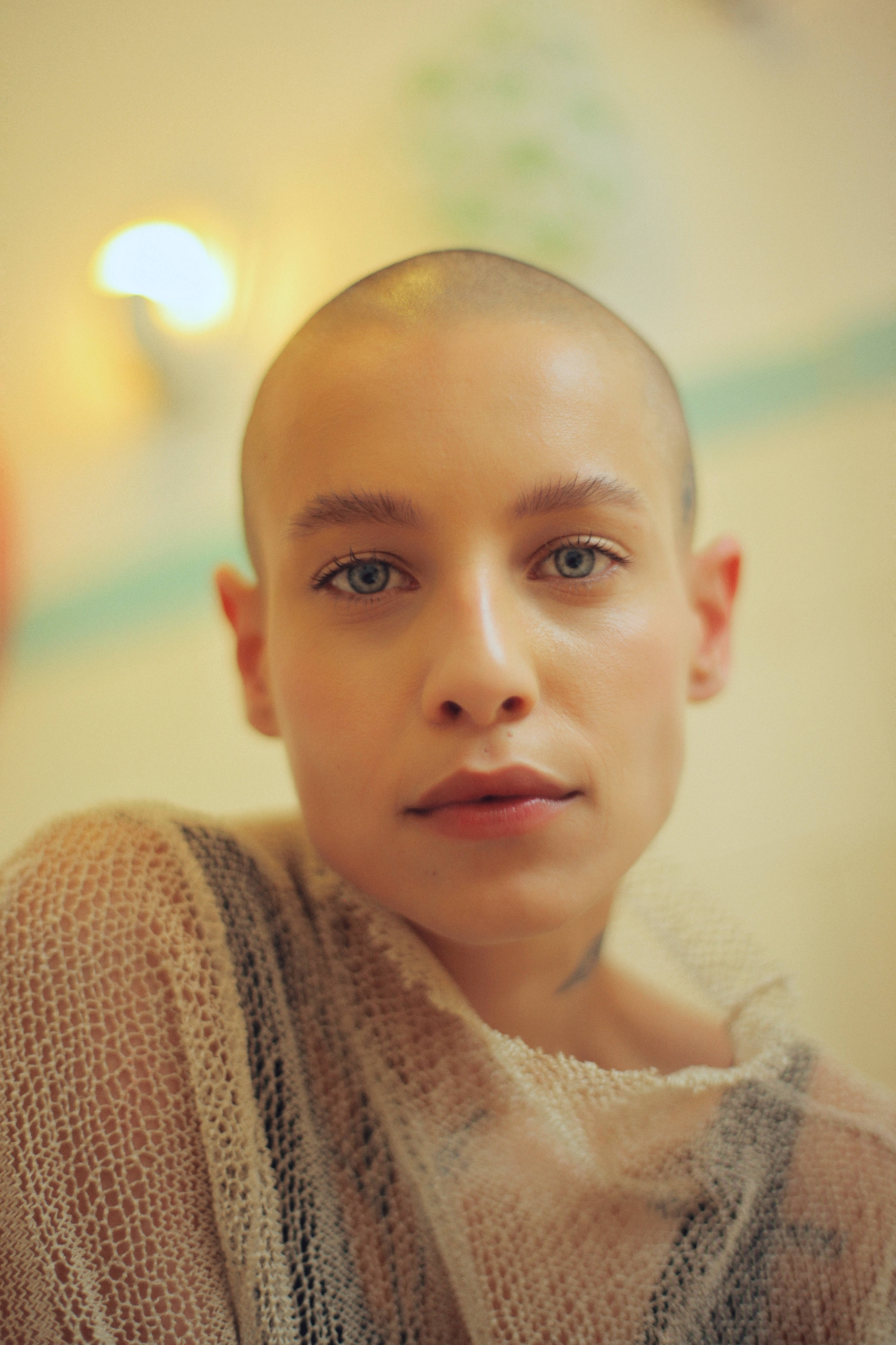 bald woman, piercing blue eyes, textured knit sweater, 5K Phone Wallpaper