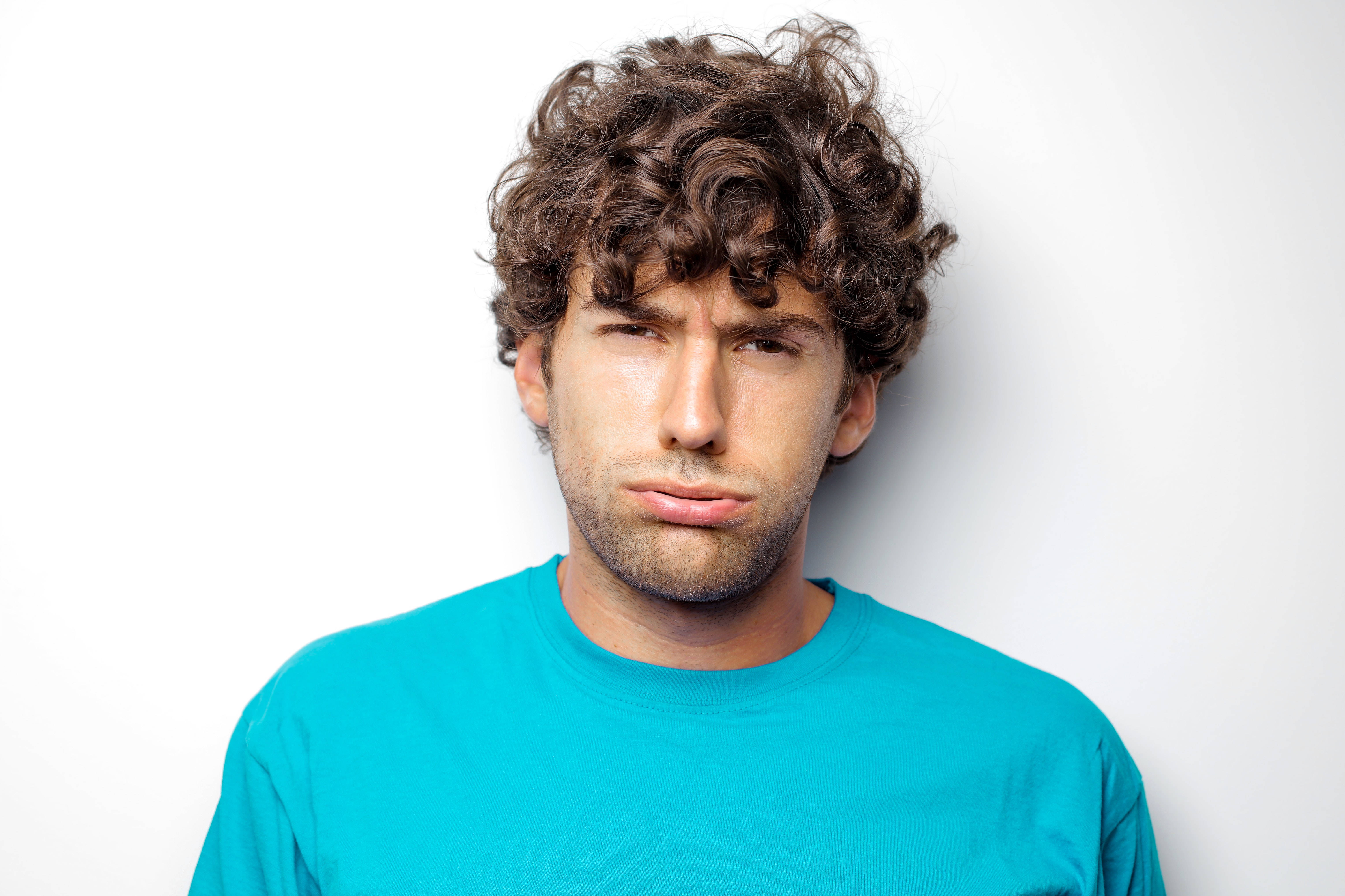 exhausted man, curly brown hair, bright blue t-shirt, 5K Desktop Wallpaper