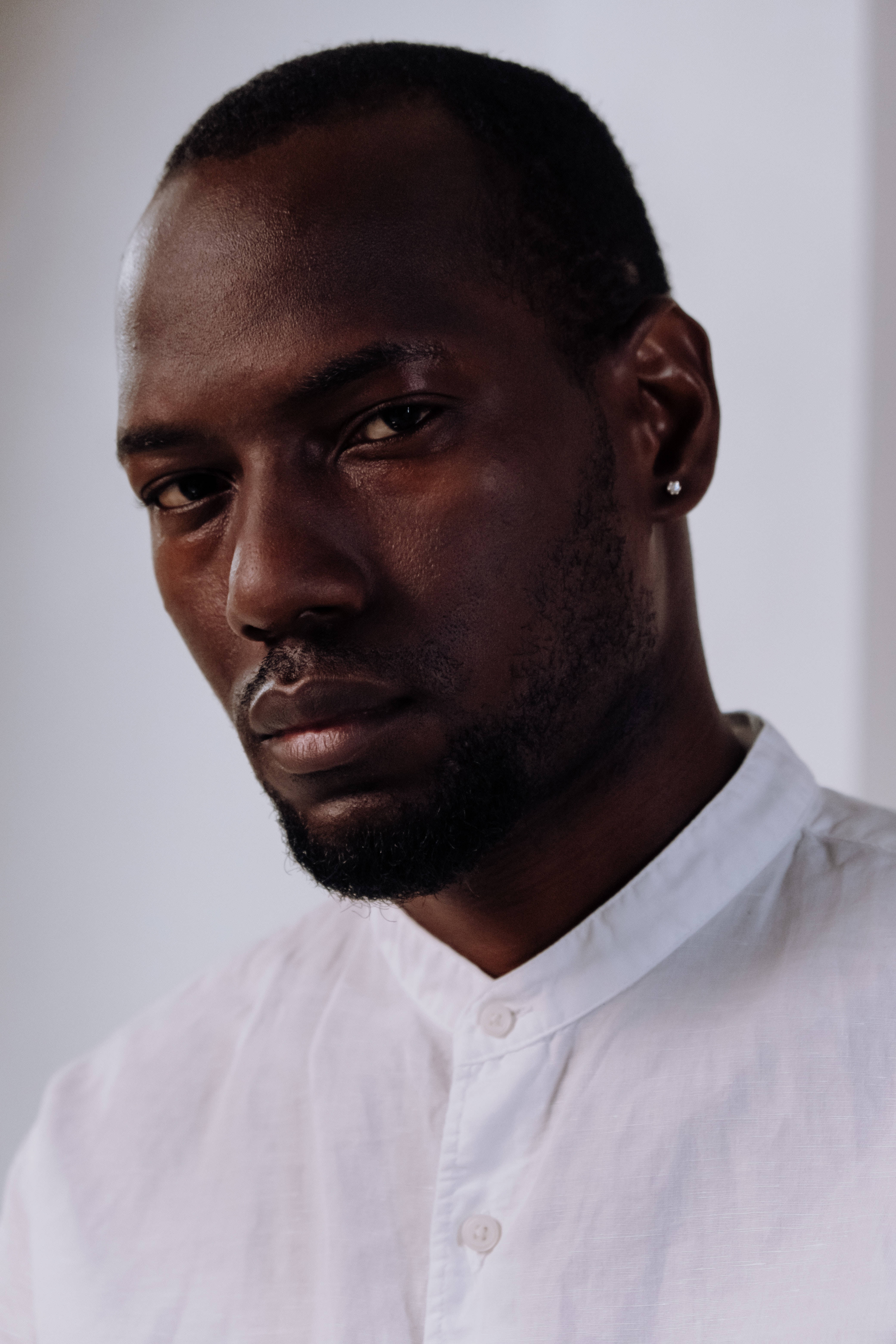 Black man, white button-up shirt, plain background, 5K Phone Wallpaper