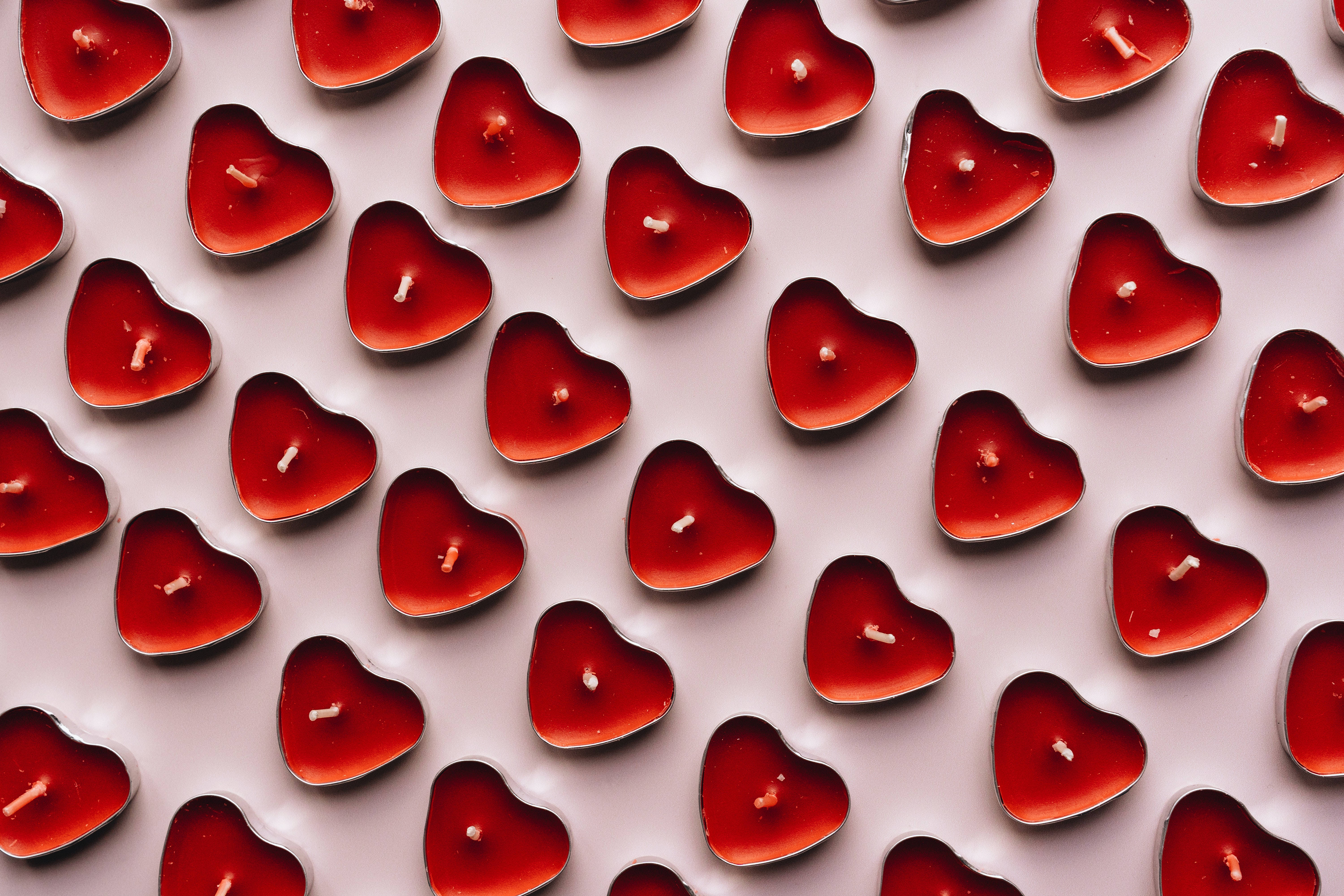red candle, heart-shaped, pale pink surface, 5K Desktop Wallpaper