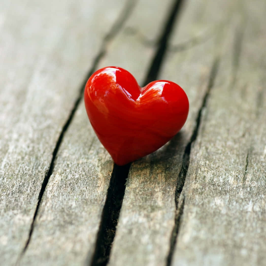 glossy red heart-shaped object, weathered wooden planks, deep cracks, SD Desktop Wallpaper