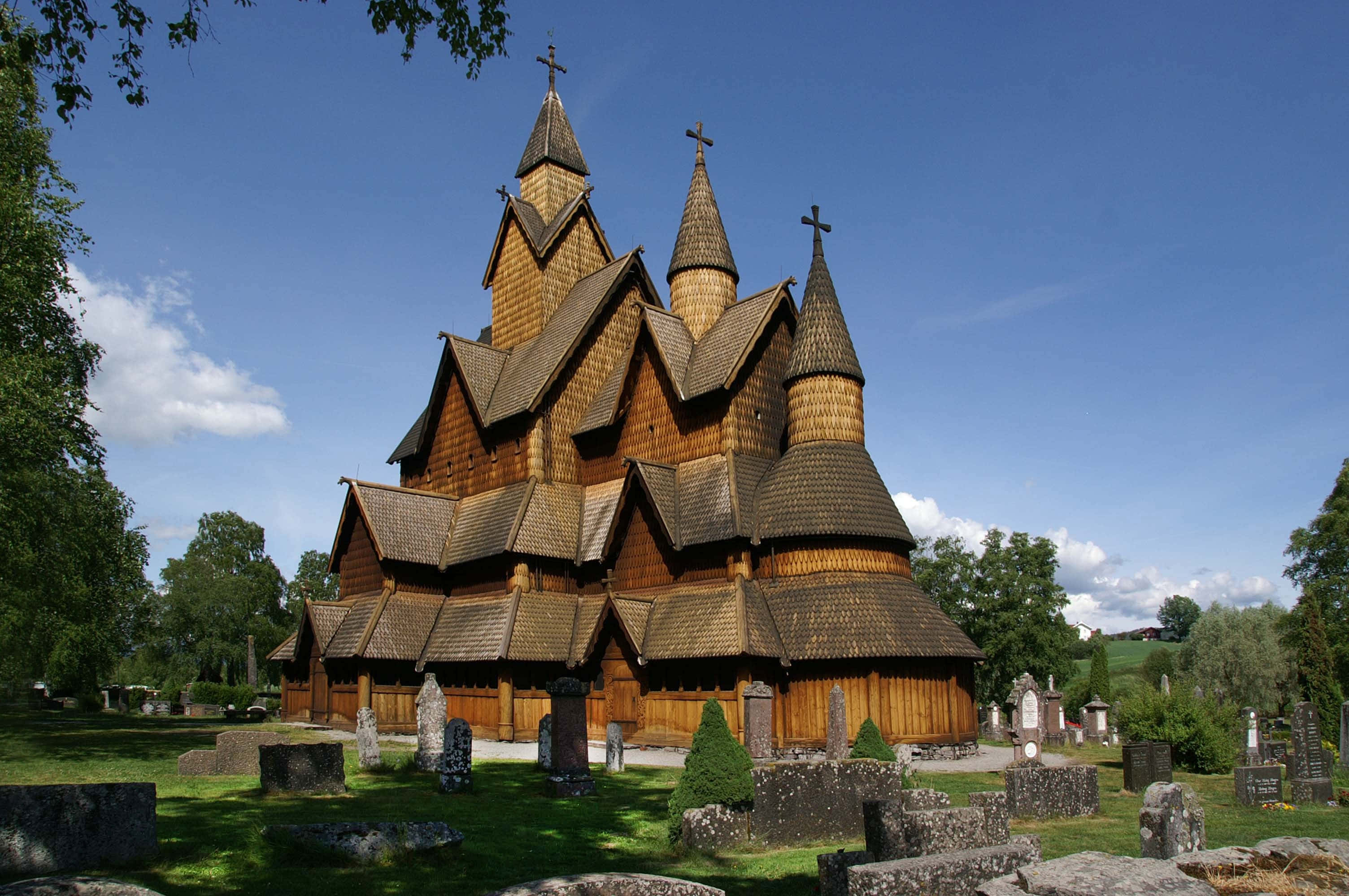 Heddal Stave Church, multiple steeples, bright blue sky, 2K Desktop Wallpaper