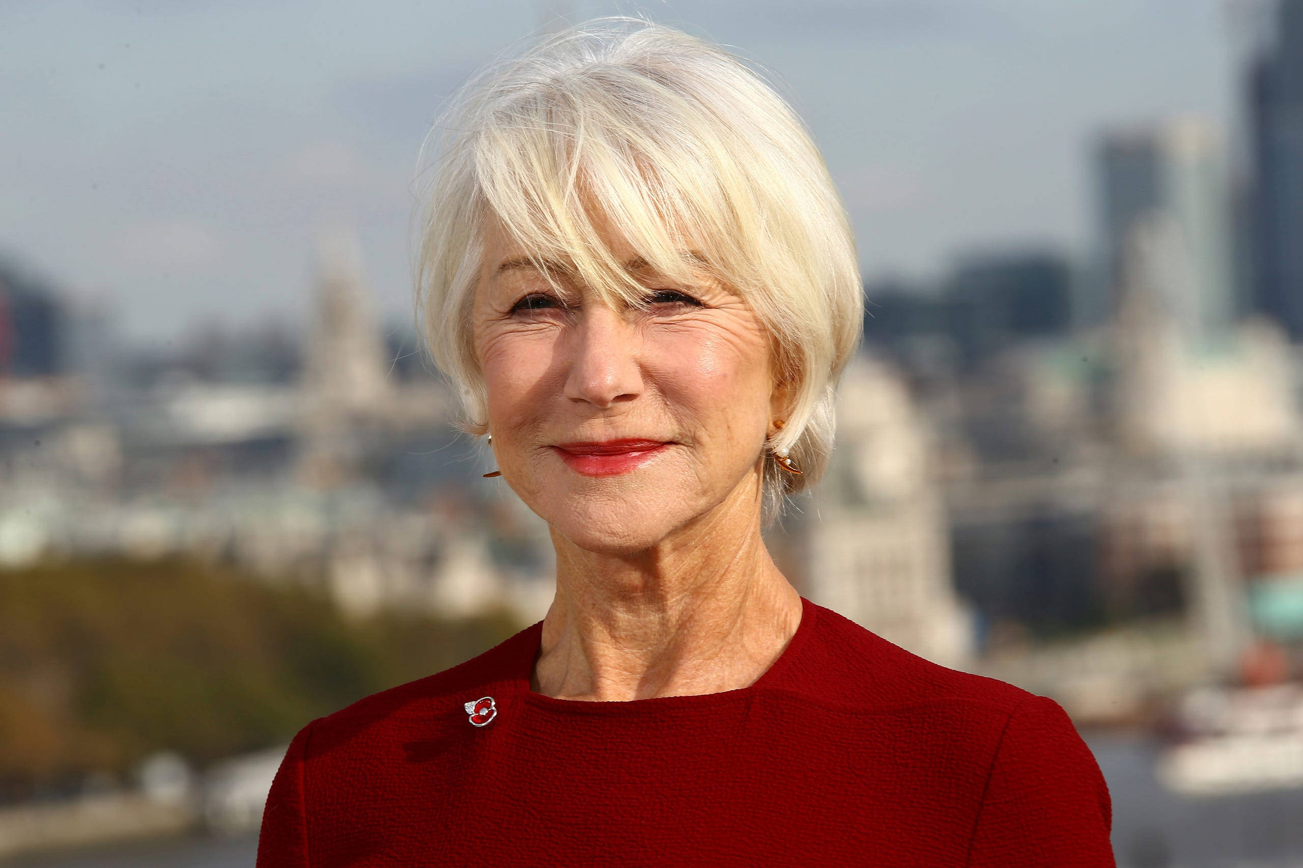 Helen Mirren, red top, blurred cityscape, 2K Desktop Wallpaper