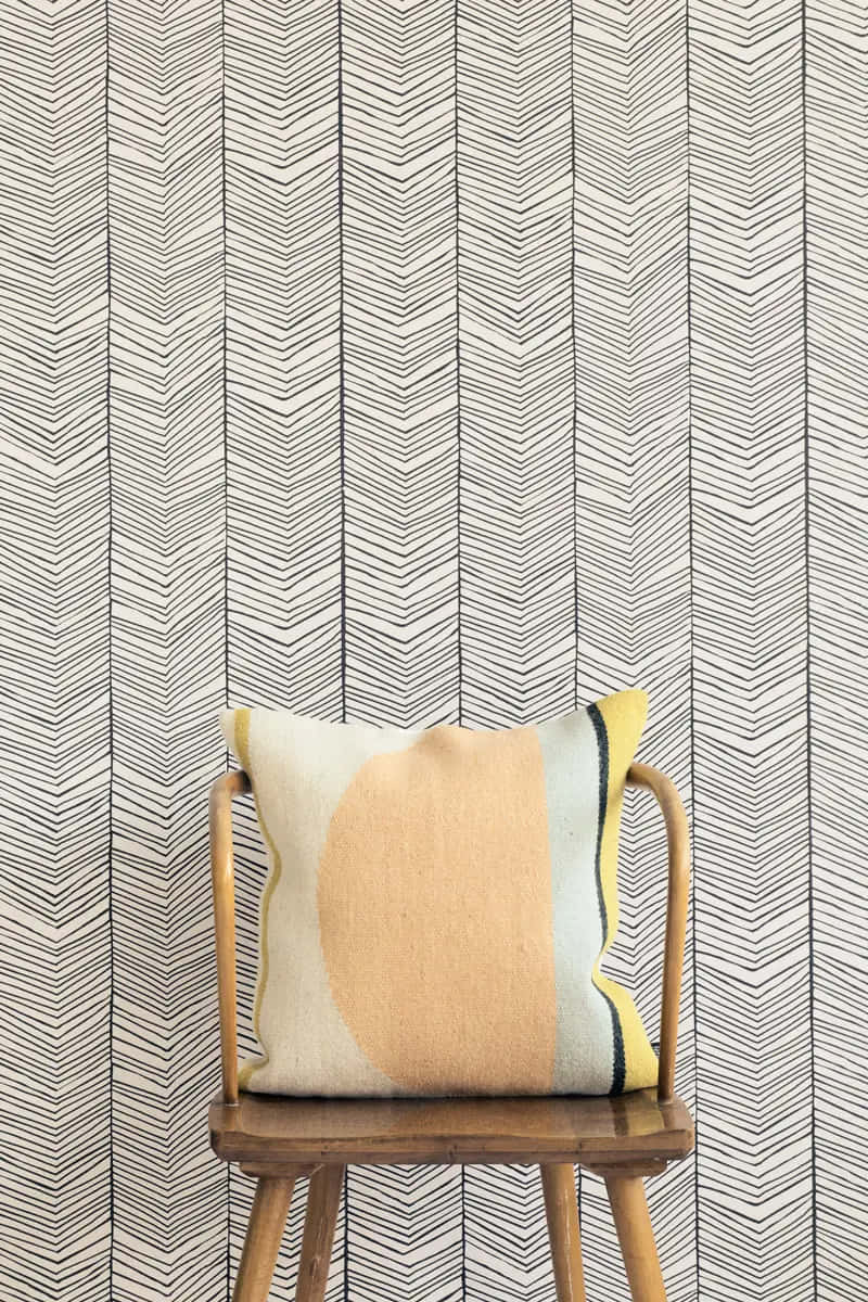 herringbone wallpaper, pastel-toned abstract pillow, wooden chair, SD Phone Wallpaper
