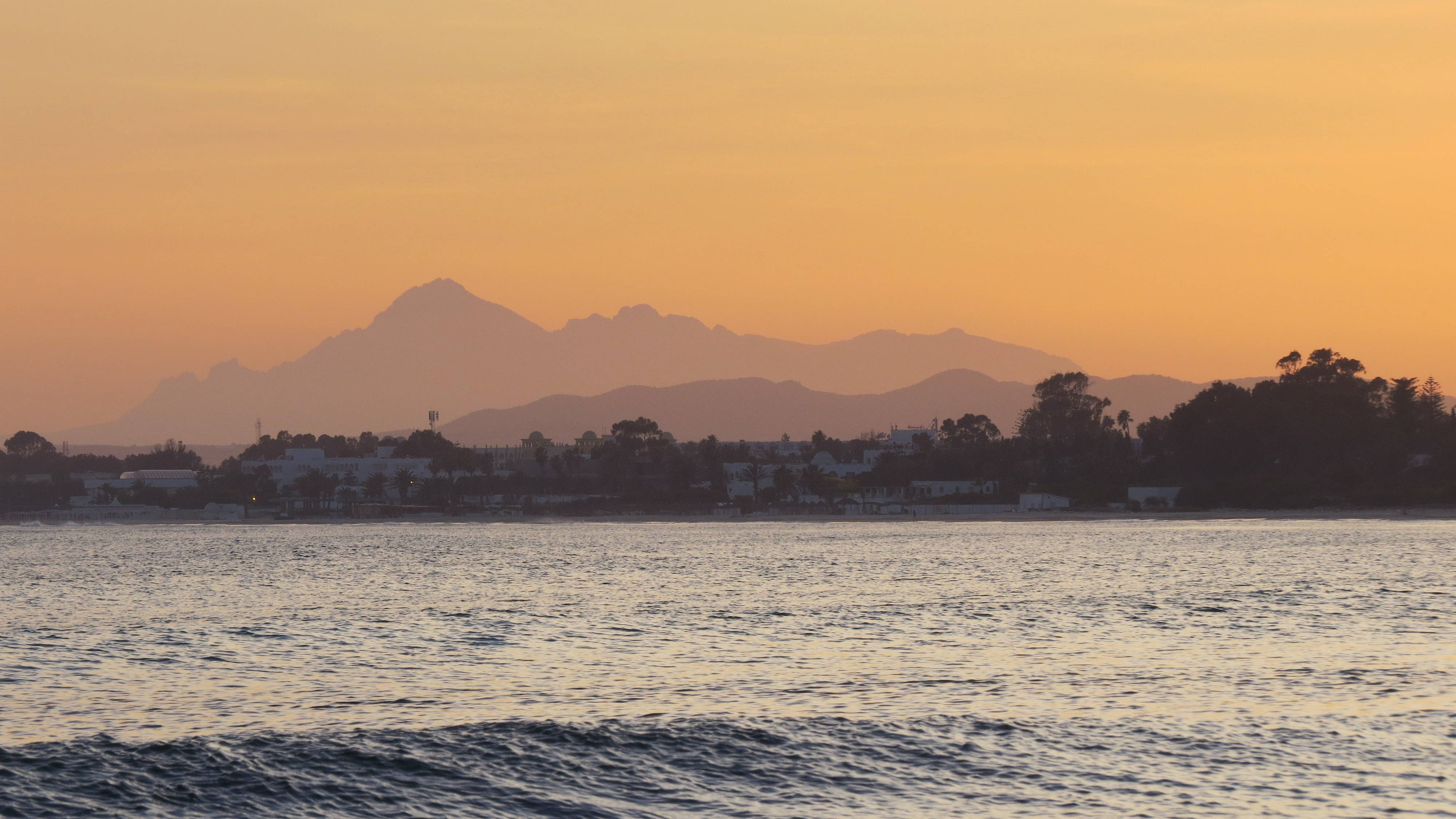Golden sunset, calm sea, distant mountain silhouette, 4K Desktop Wallpaper