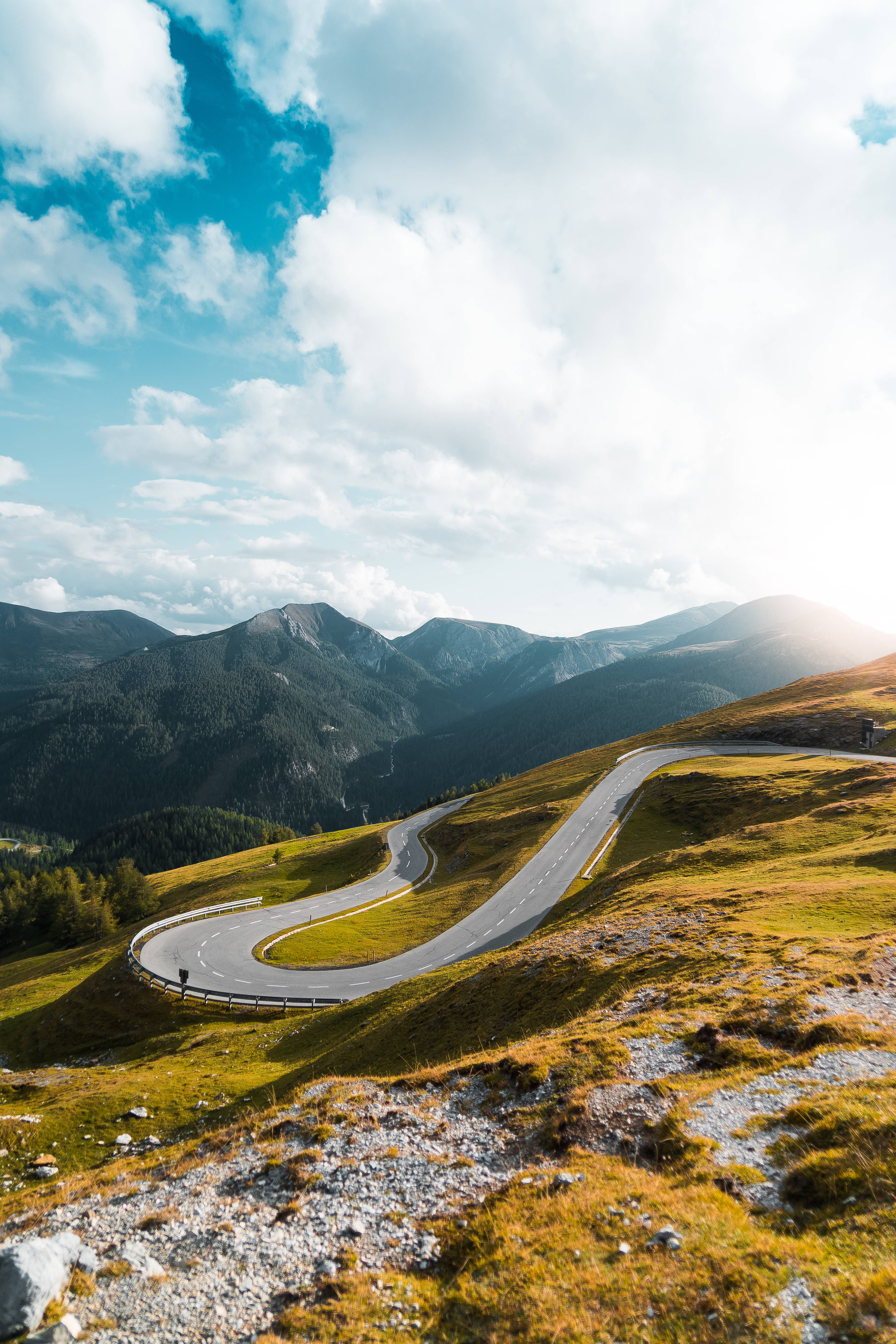 mountain road, sunlit grassy hills, bright blue sky, 5K Phone Wallpaper