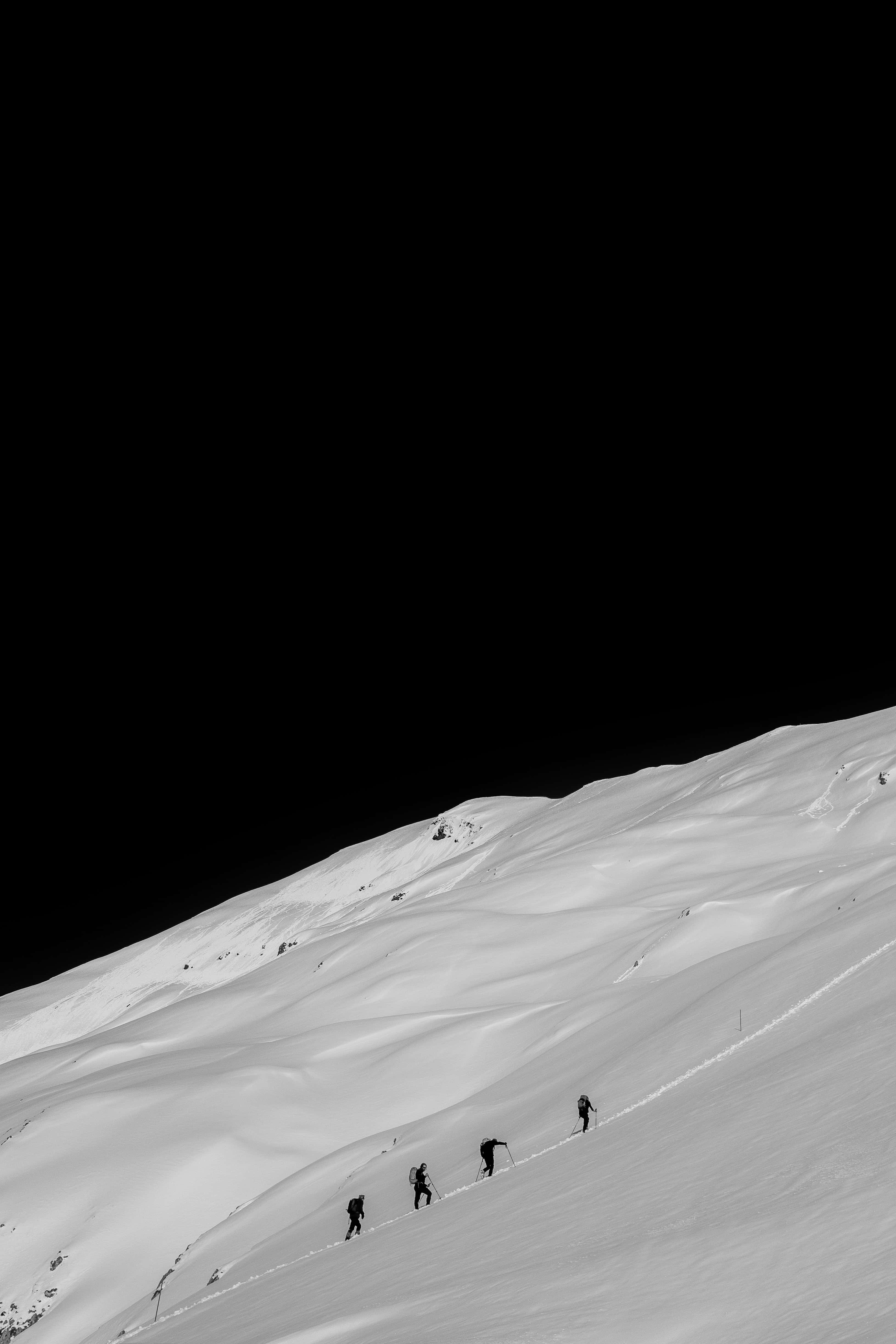 snow-covered mountain slope, steep snow-covered mountain slope, stark black sky, 4K Phone Wallpaper