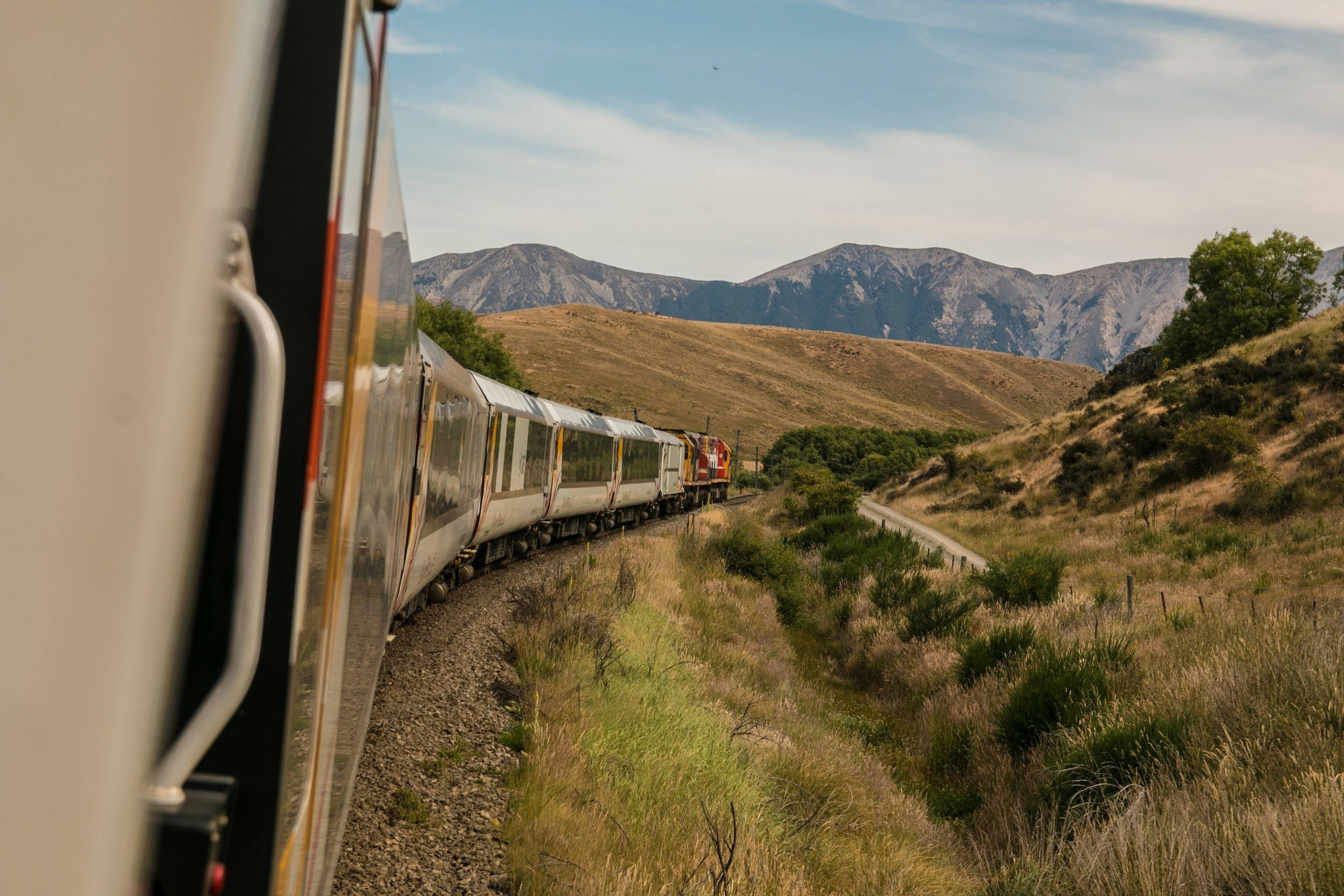 silver passenger train, golden grassy hills, distant mountains, Full HD Desktop Wallpaper