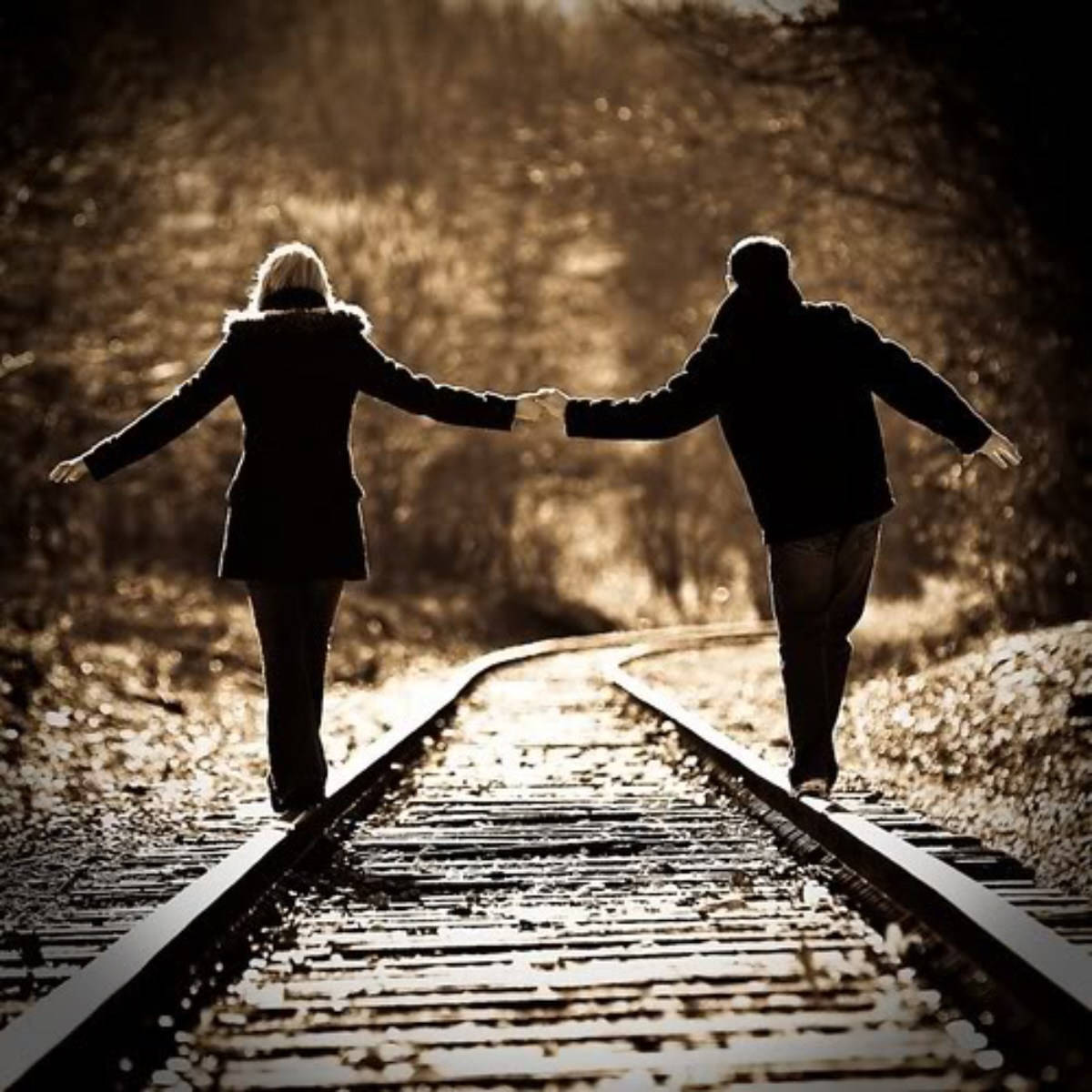 vintage holding hands on the rails, sunlit railway track, golden-hued forest, SD Desktop Wallpaper
