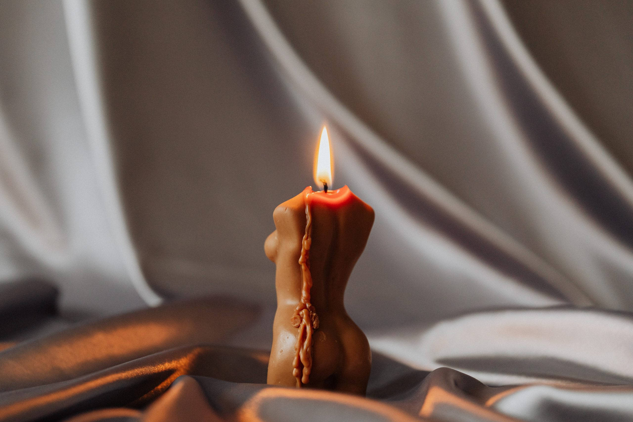 holistic lit woman shaped candle, female torso, red candle, 2K Desktop Wallpaper
