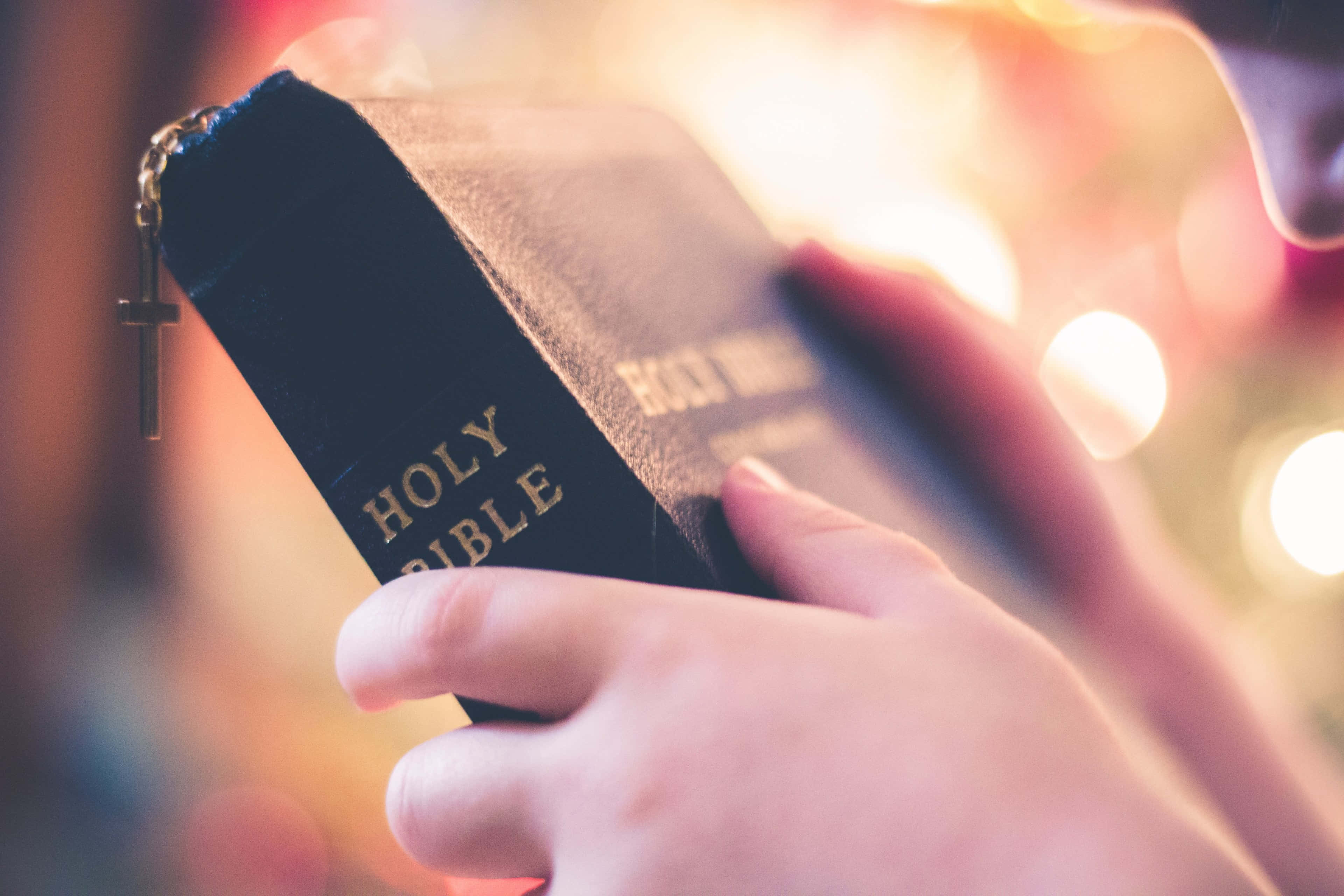 Holy Bible, black leather-bound, gold lettering, 4K Desktop Wallpaper