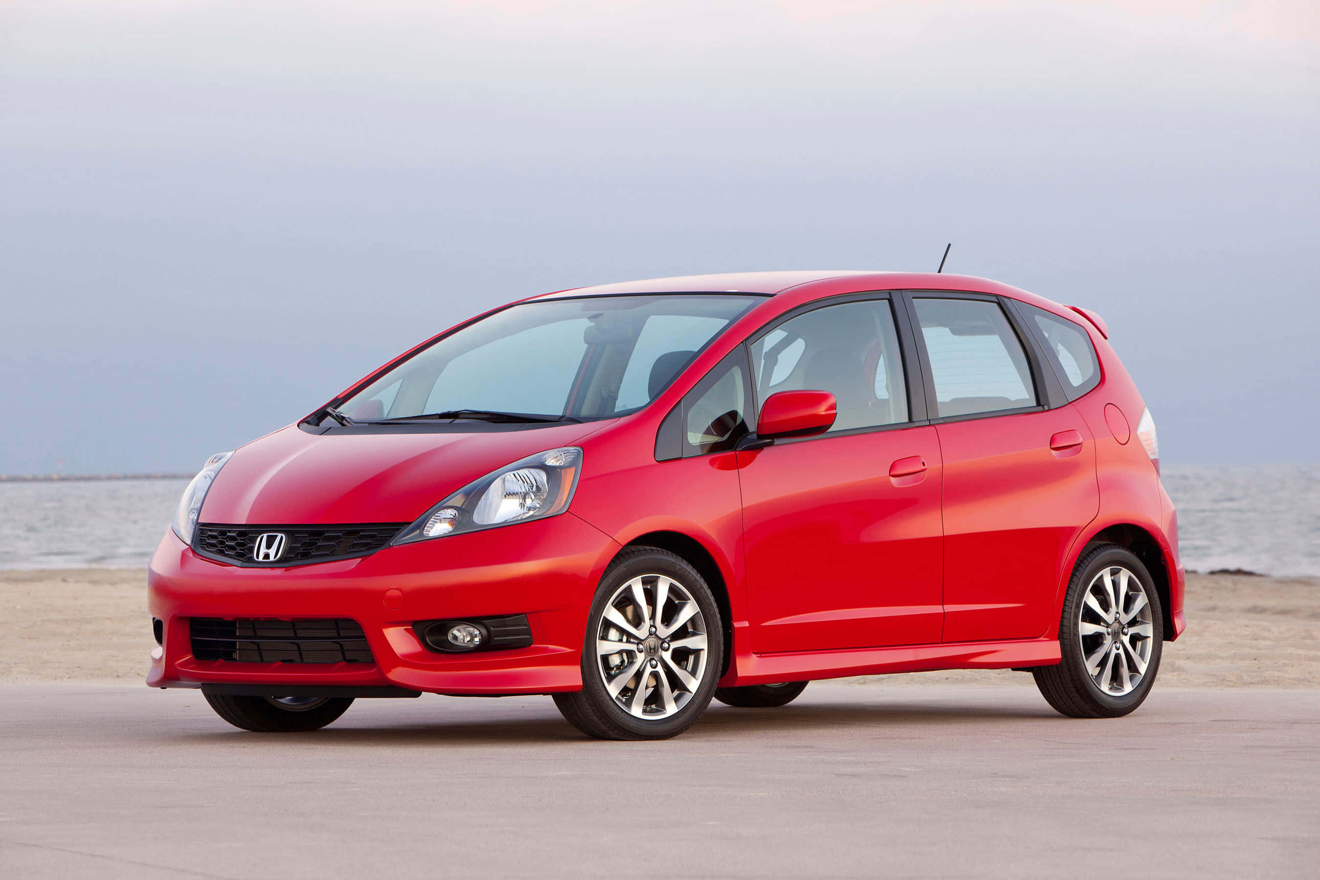 Honda Fit, vibrant red, sandy beach, 2K Desktop Wallpaper